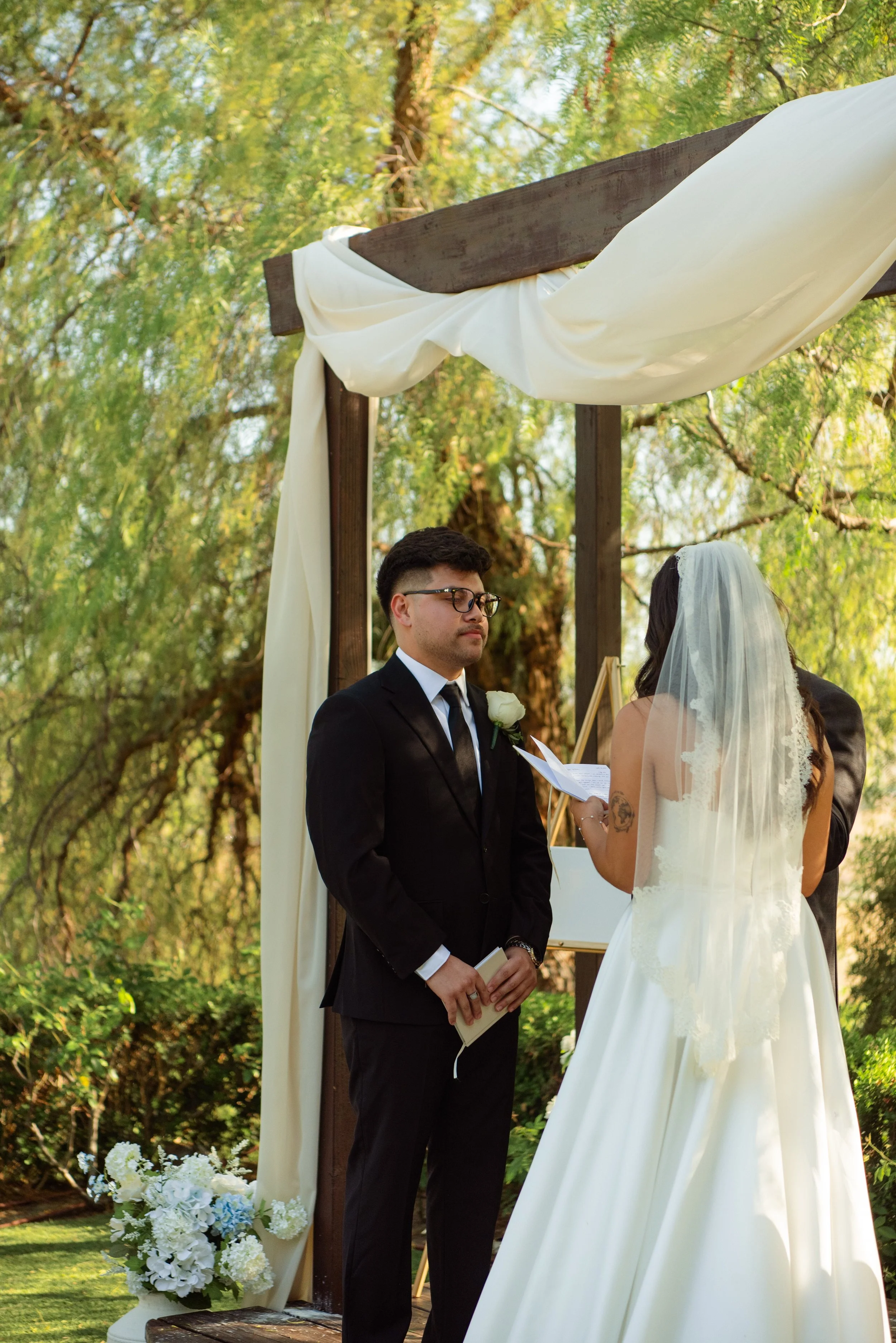 Shot of groom looking at his bride and she reads her vows