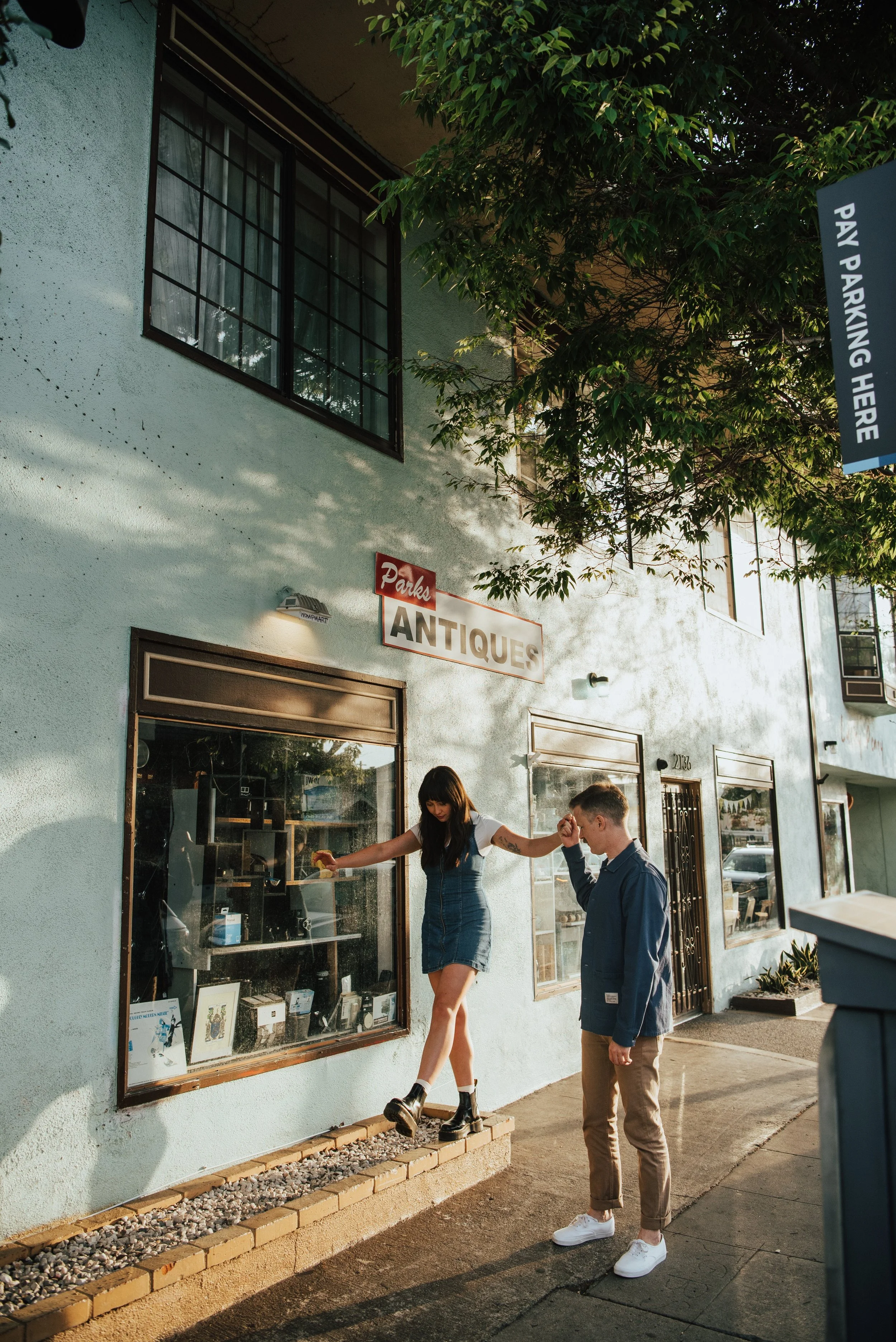 Guys helping woman walk on an raised edge on the sidewalk