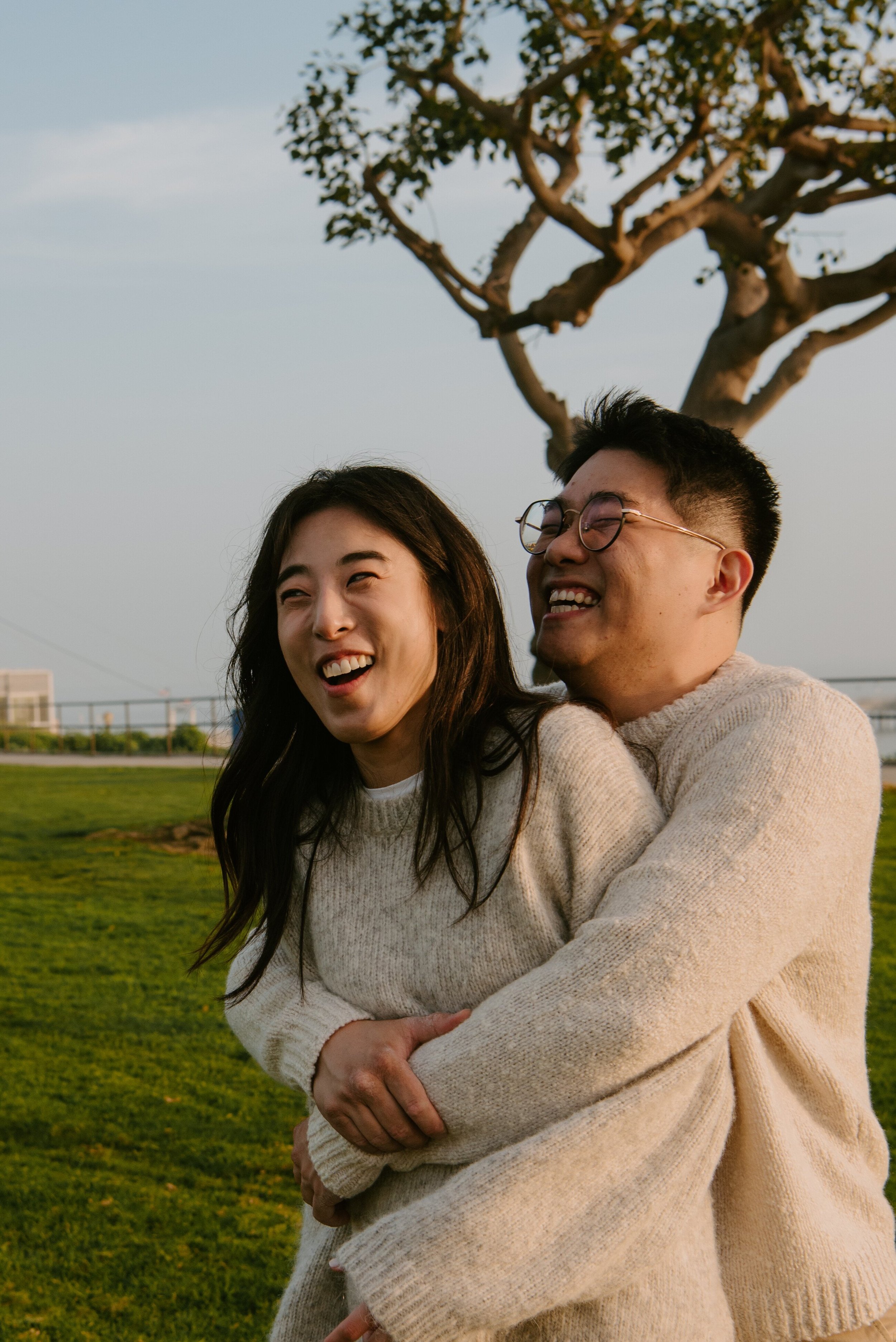 Couple smiling as guy grabs girl from behind