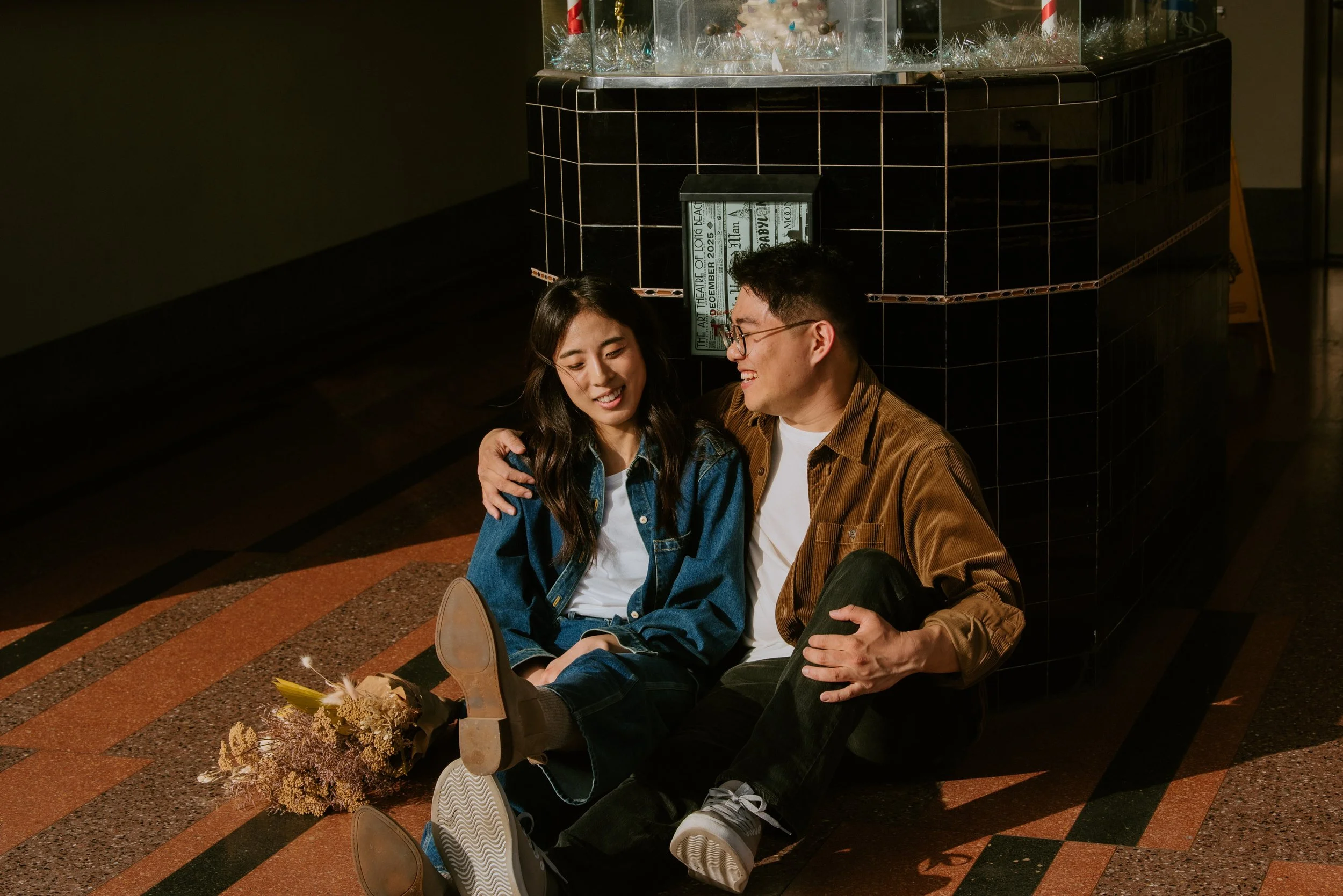 Guy and girl sitting on the tile ground talking with each other