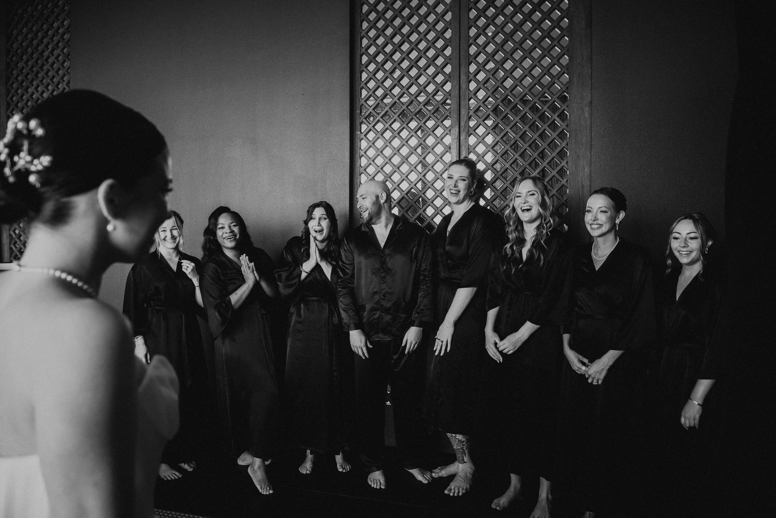 Black and white photo of bride having a first look with her wedding party