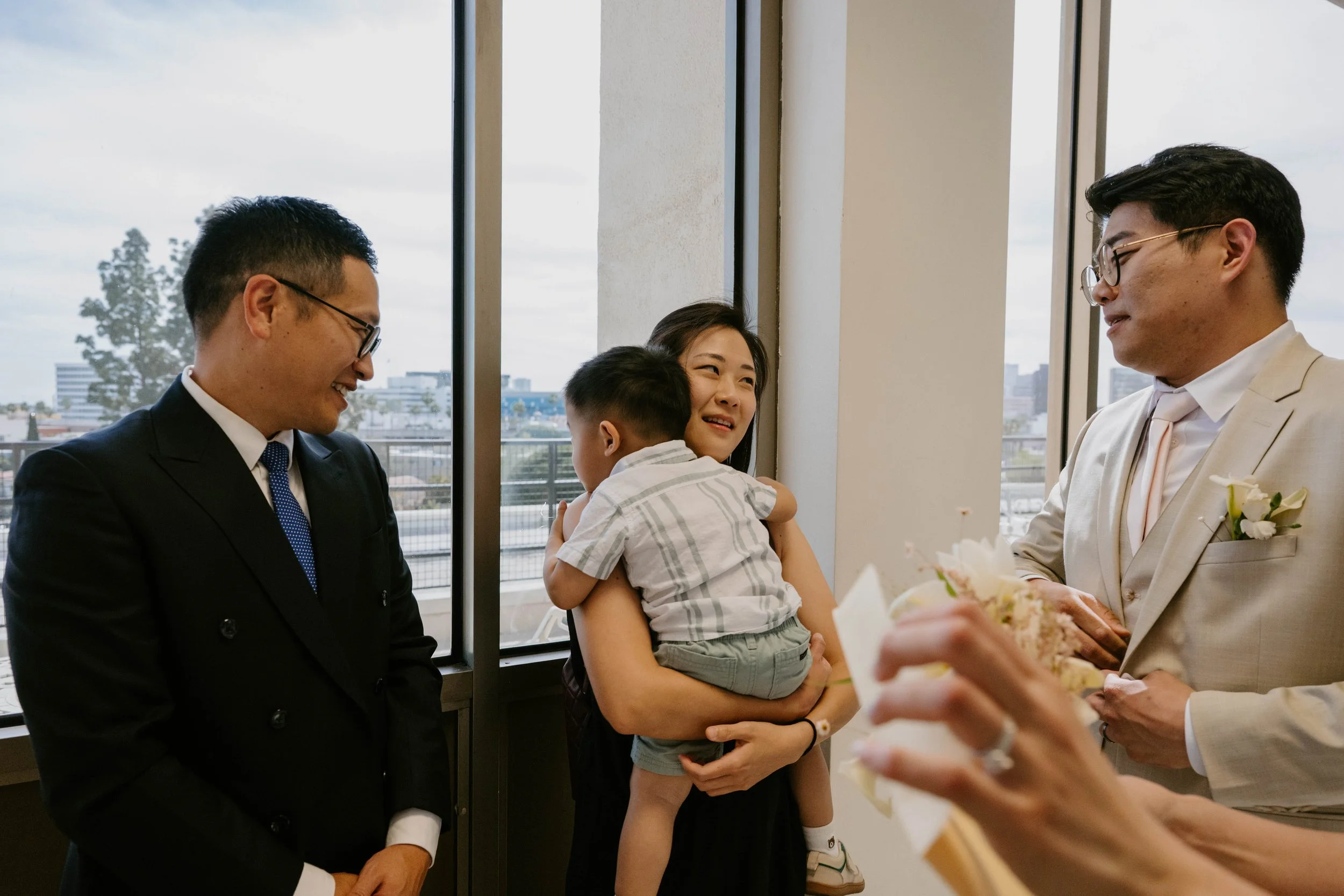 Groom talking with family in hallway