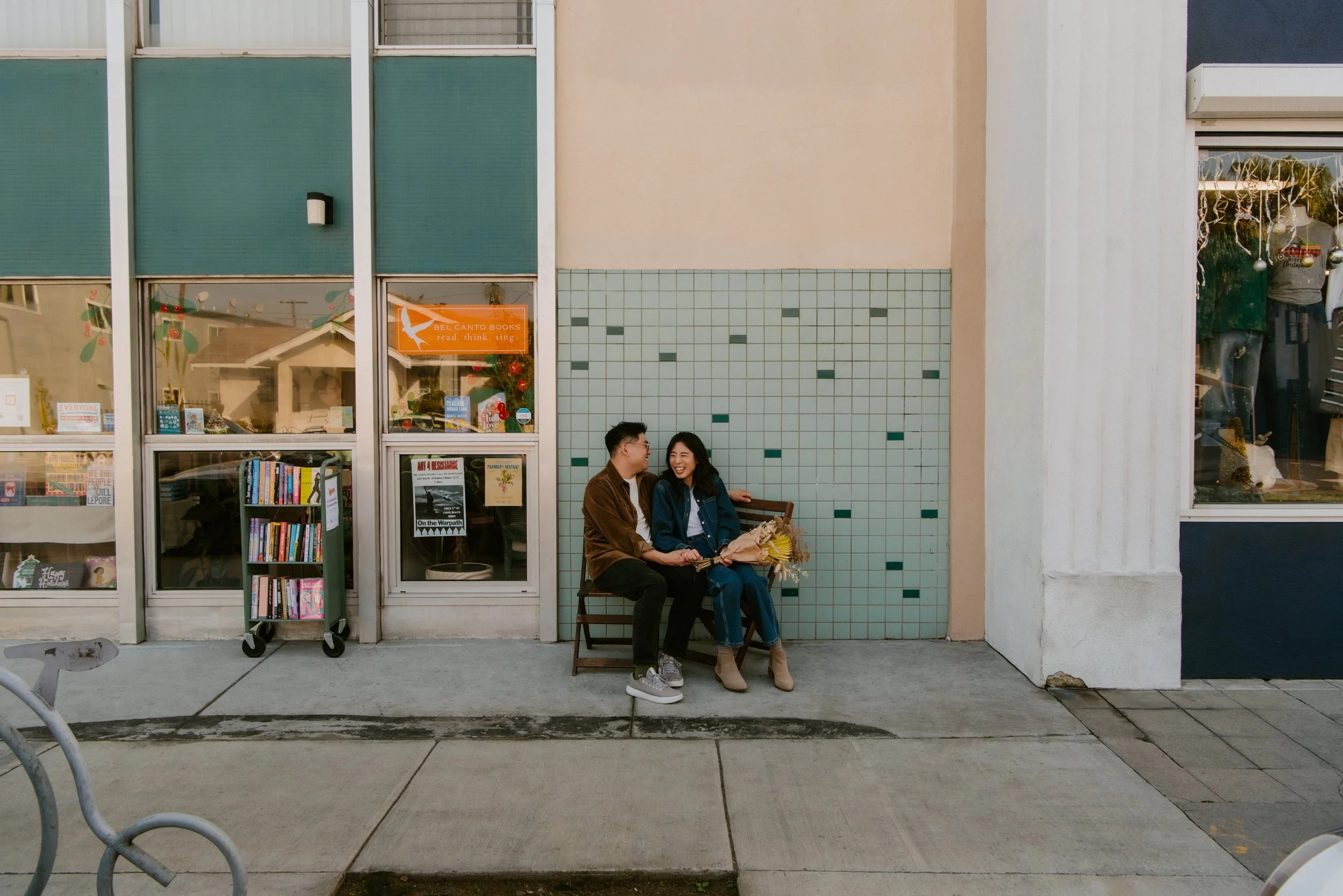 Couple sitting in chairs in from of a Library laughing