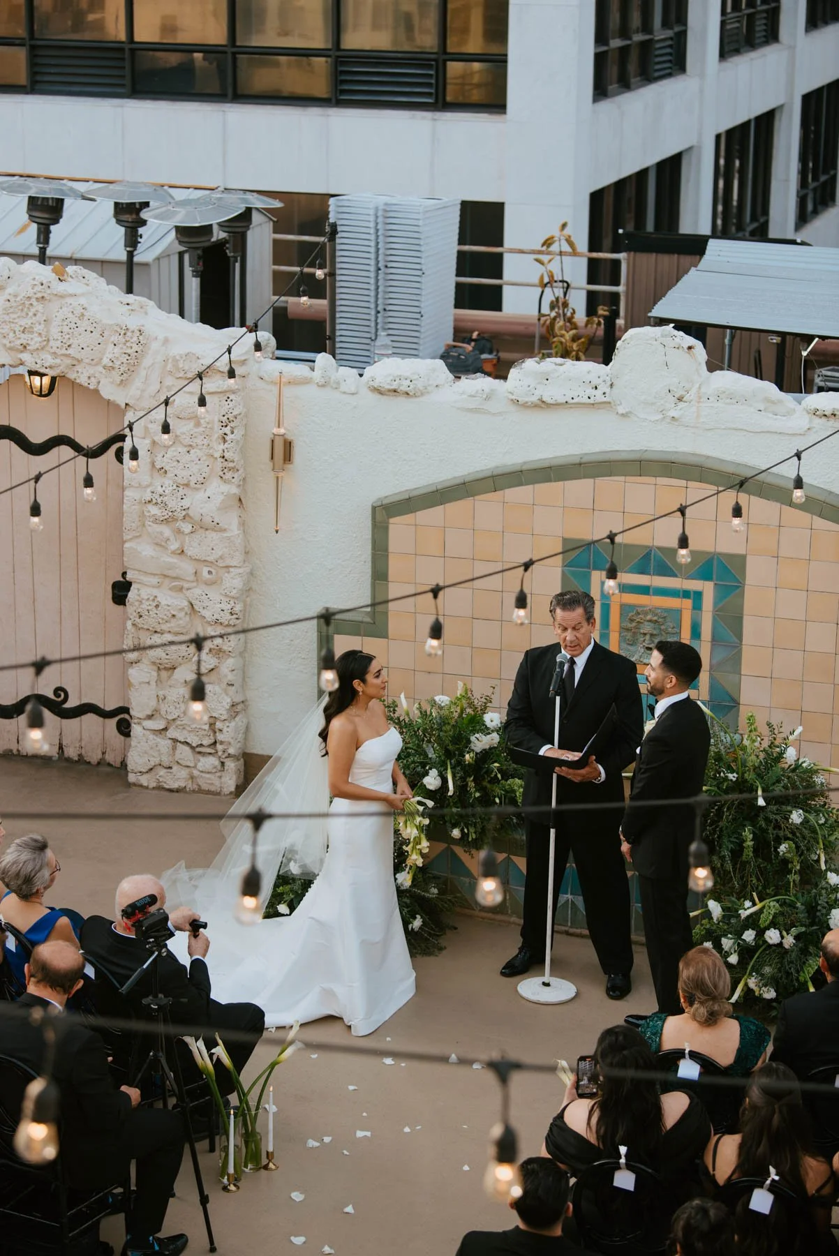 shot from a above looking down on the bride and groom's ceremony and the minister speaks
