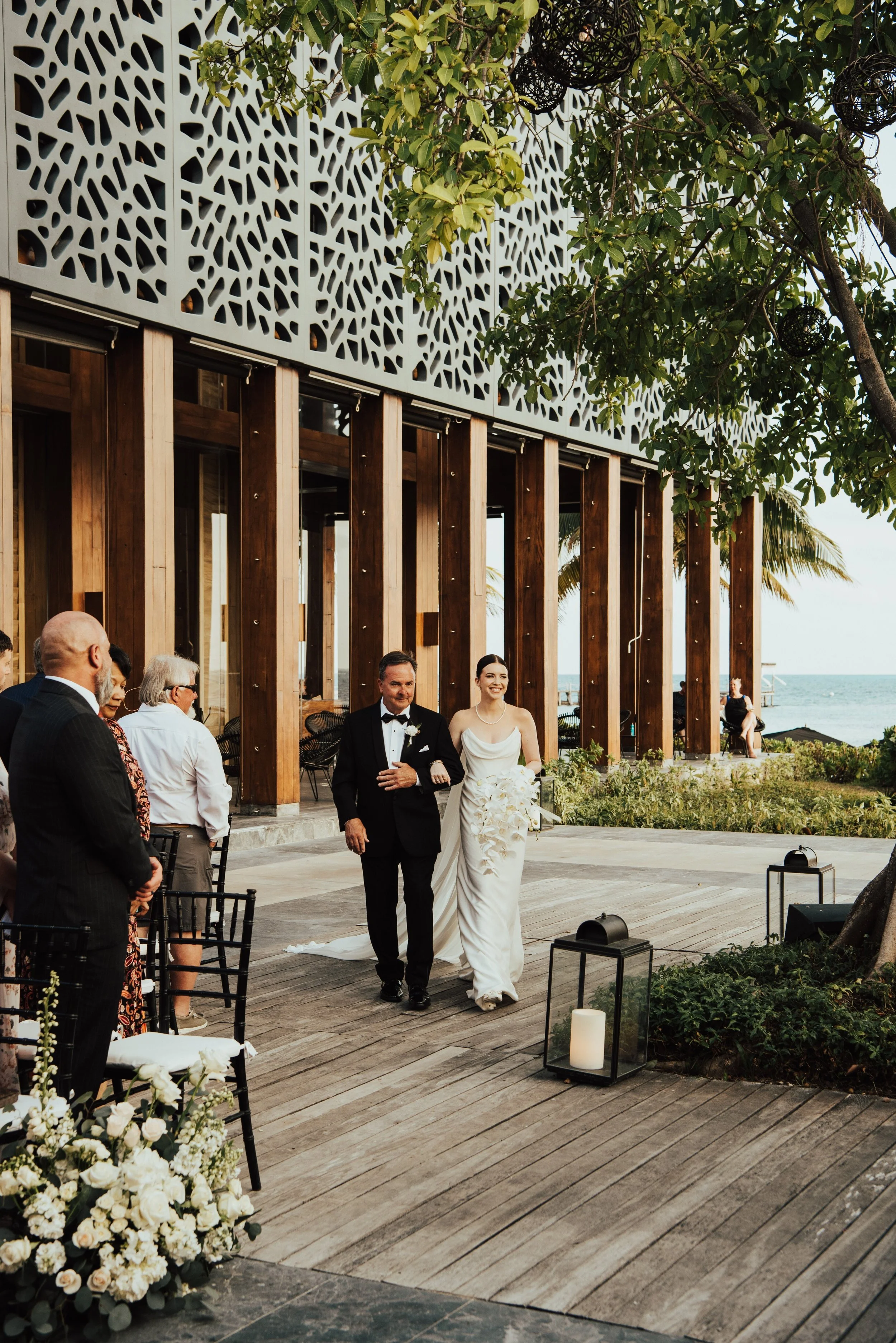 bride and her father walking up the wedding ceremony aisle smiling