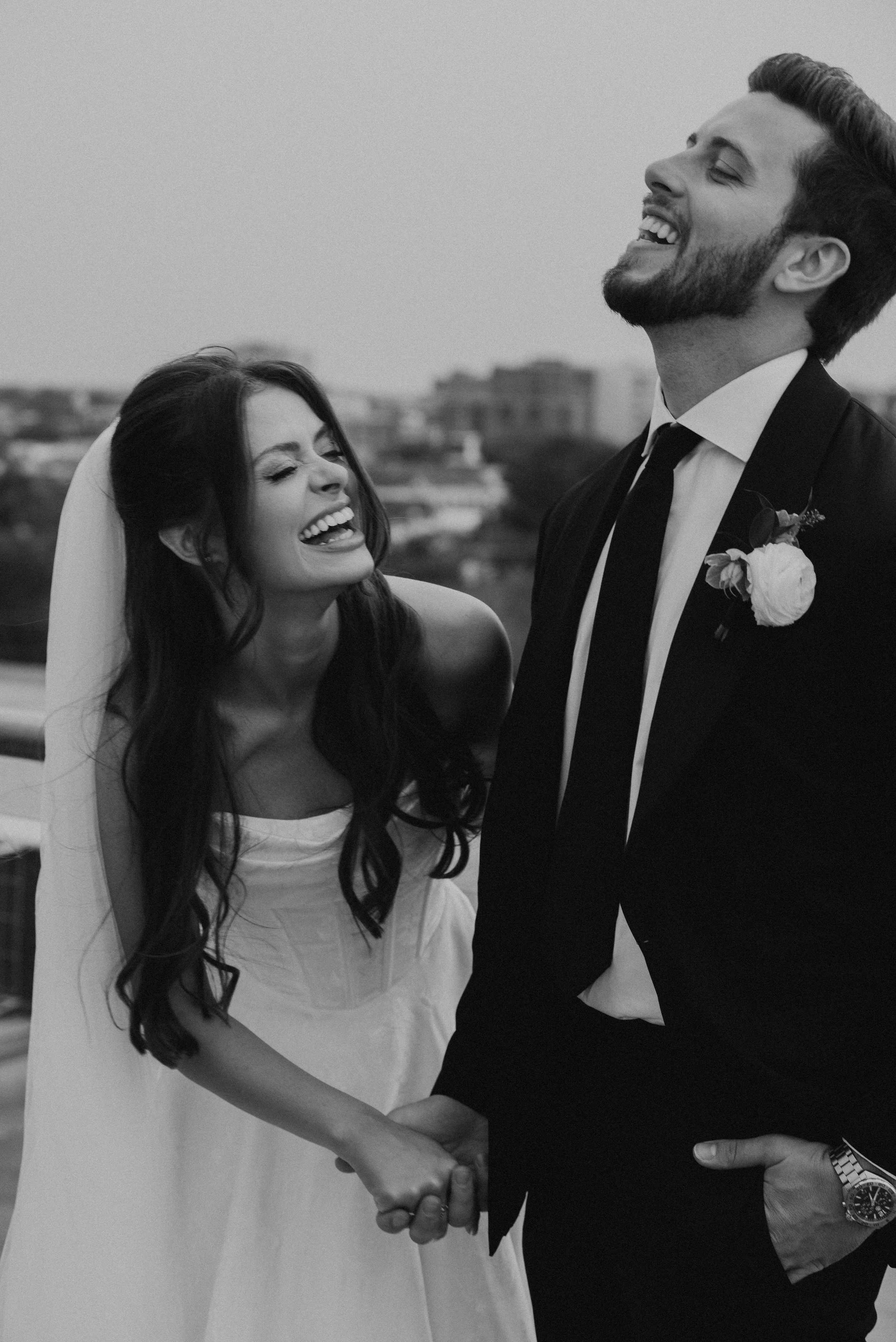 black and white photo of bride and groom laughing together