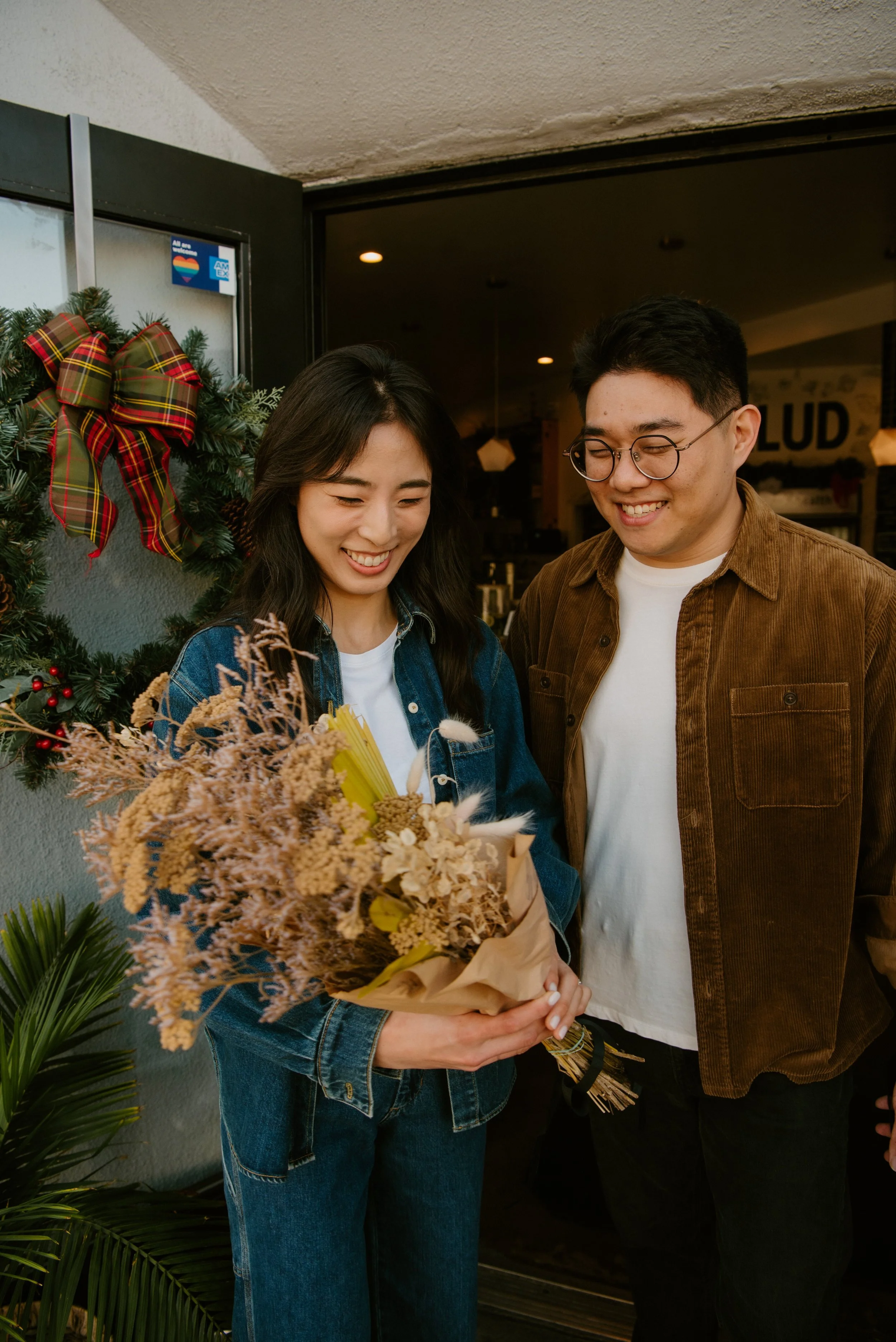 Guy and girl smile at the flowers he picked out for her