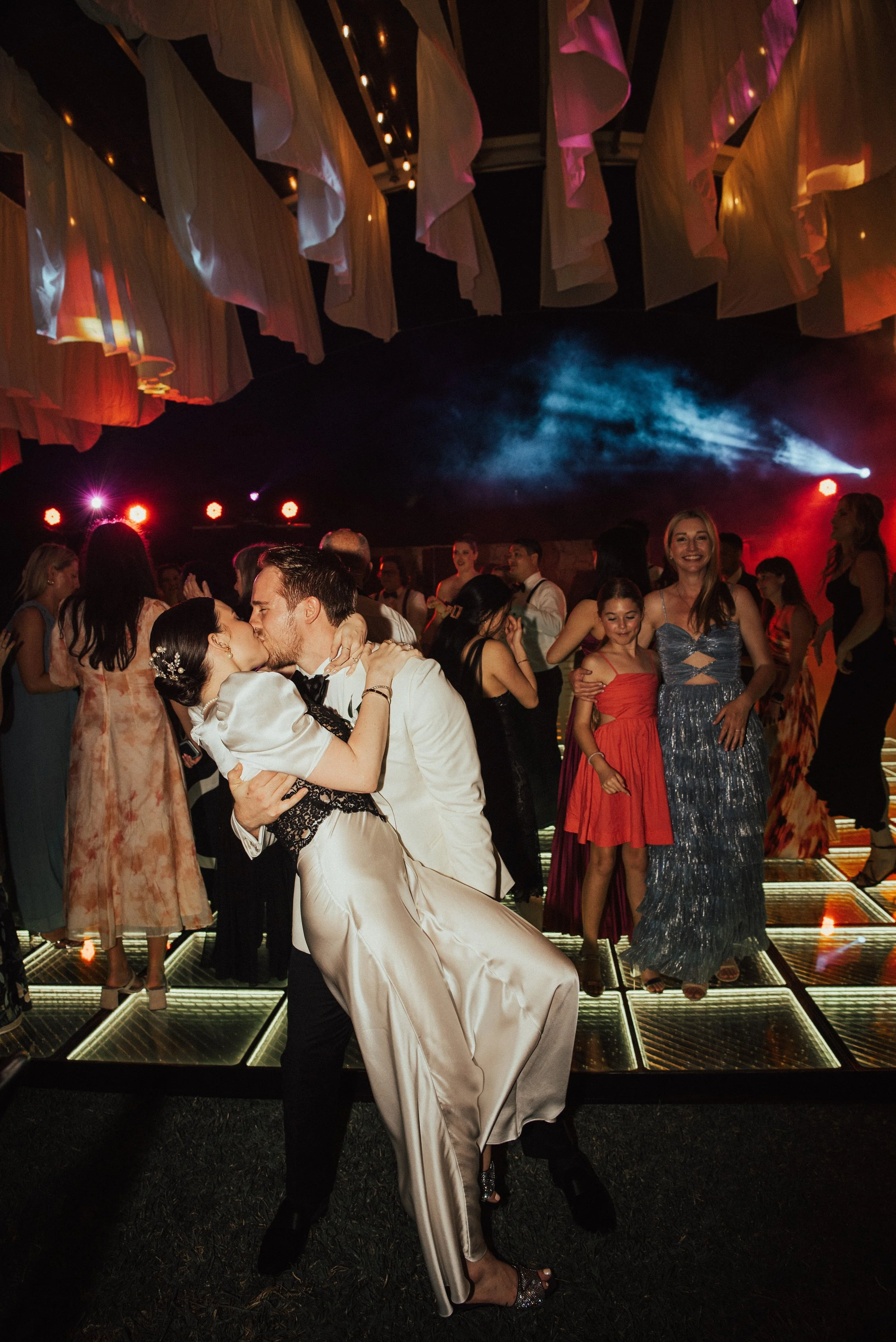 groom dipping his bride for a kiss on the dance floor at their wedding reception