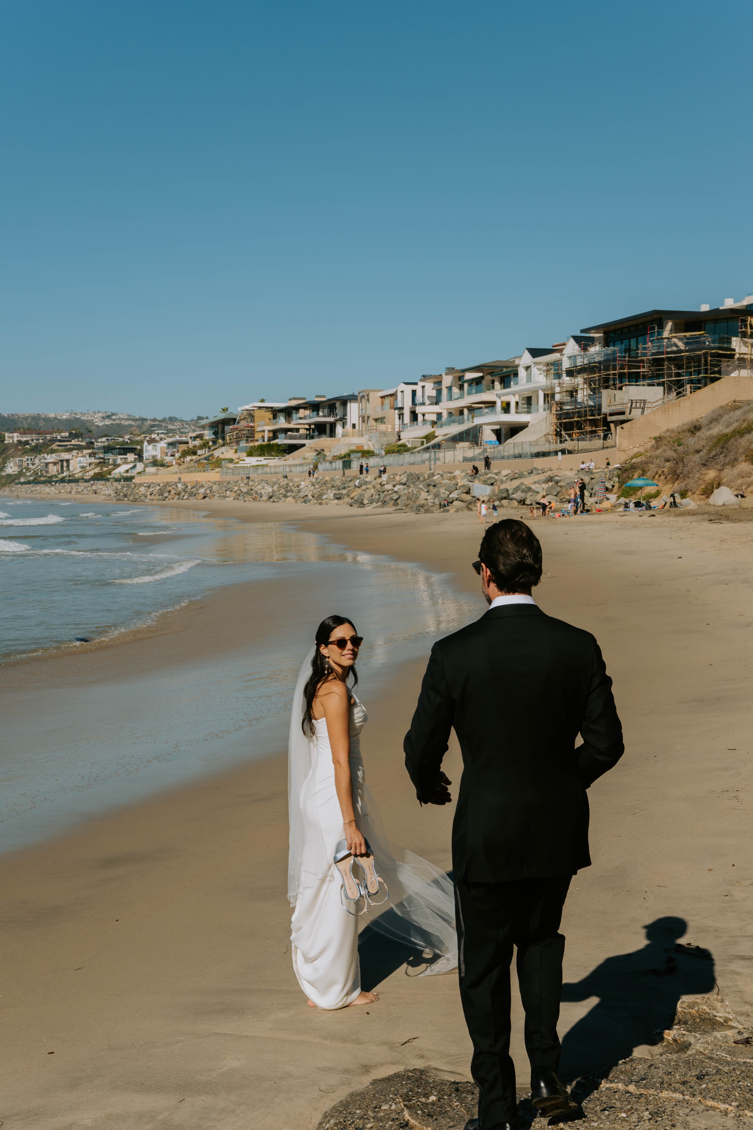 Bride wearing sunglasses looking back at a groom