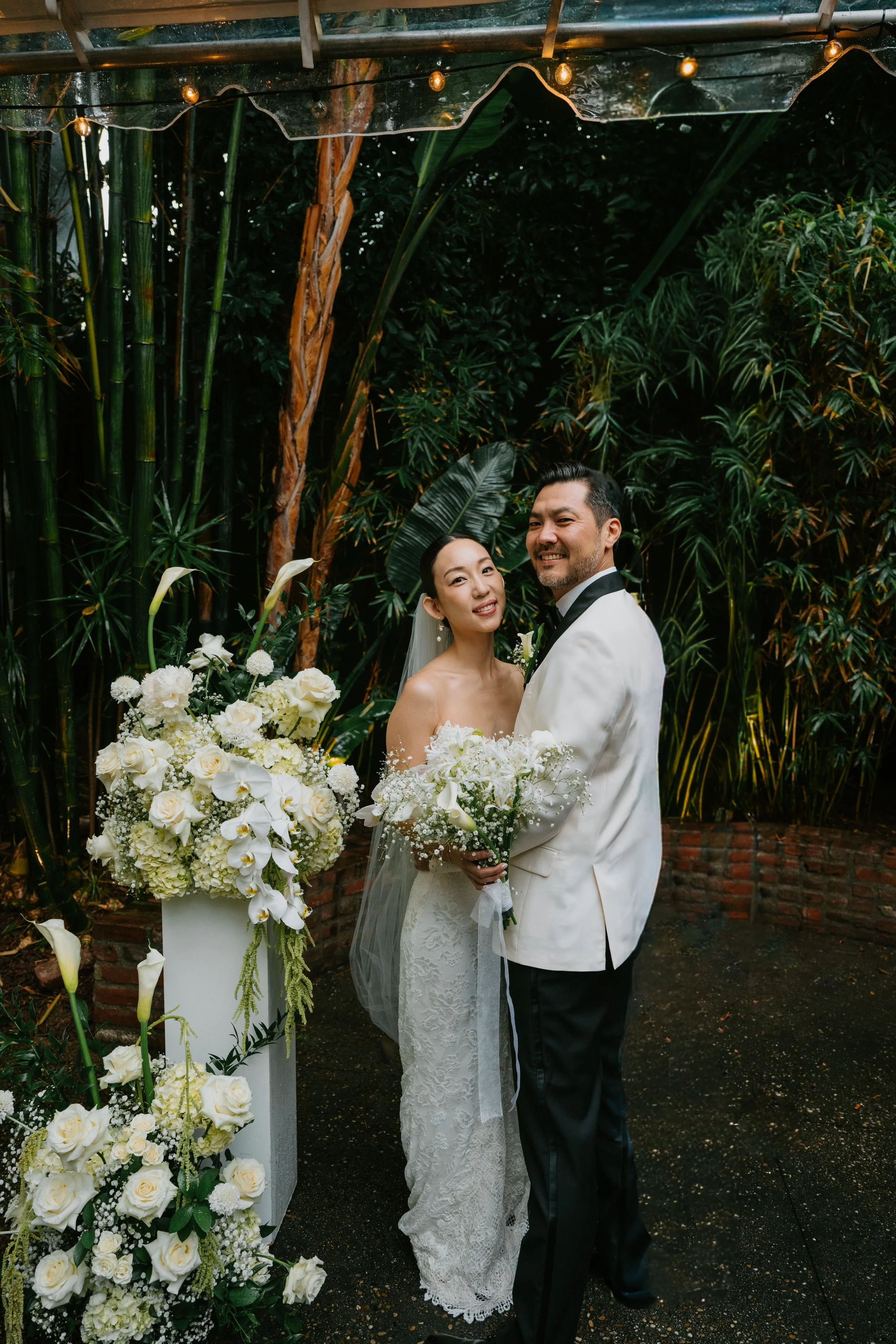 Bride and groom standing next to each other smiling at camera.