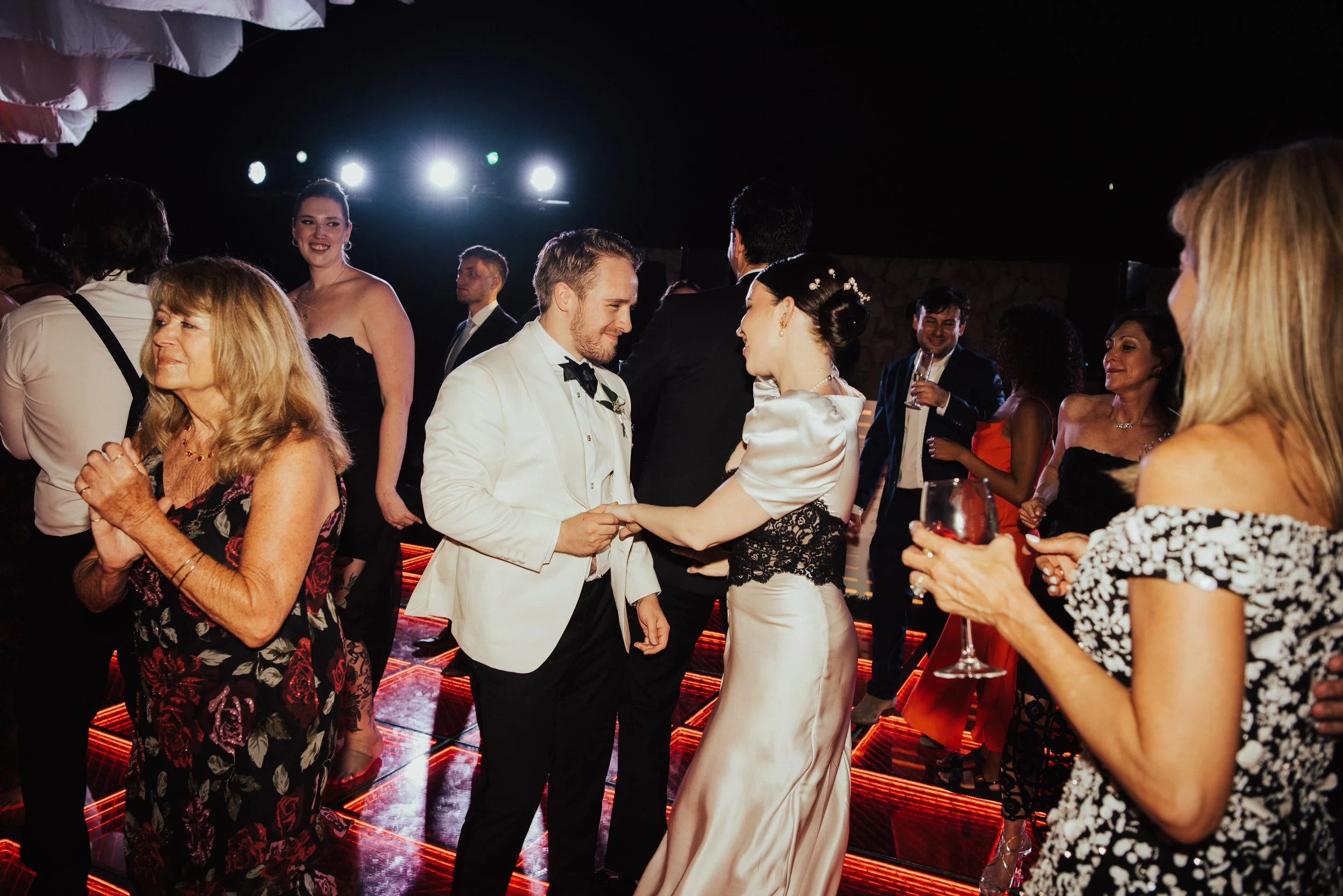 Bride and groom dancing, surrounded by their guest