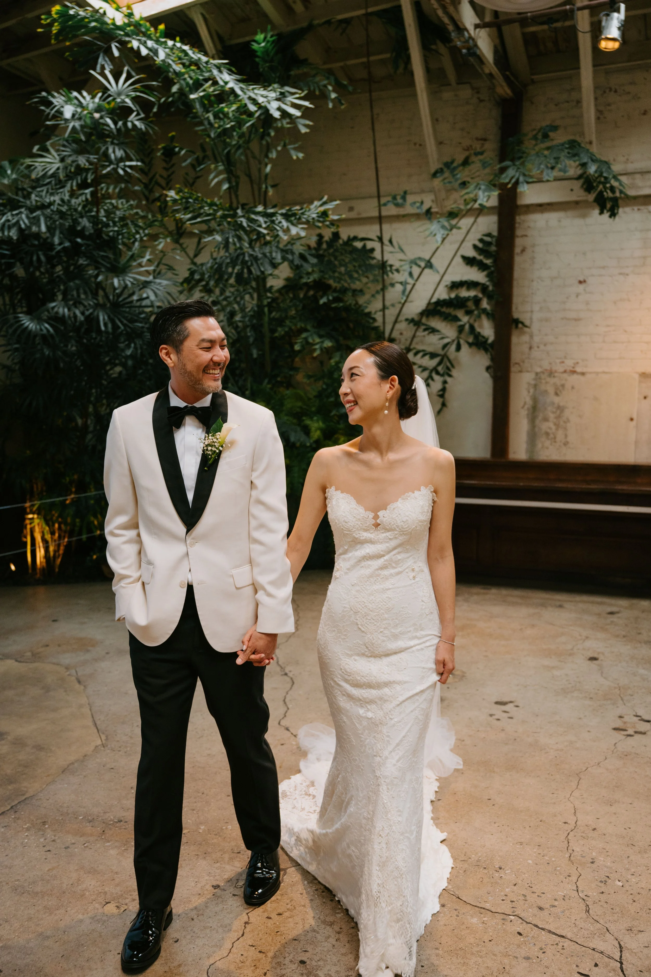 Bride and groom Walking holding hands and smiling at each other