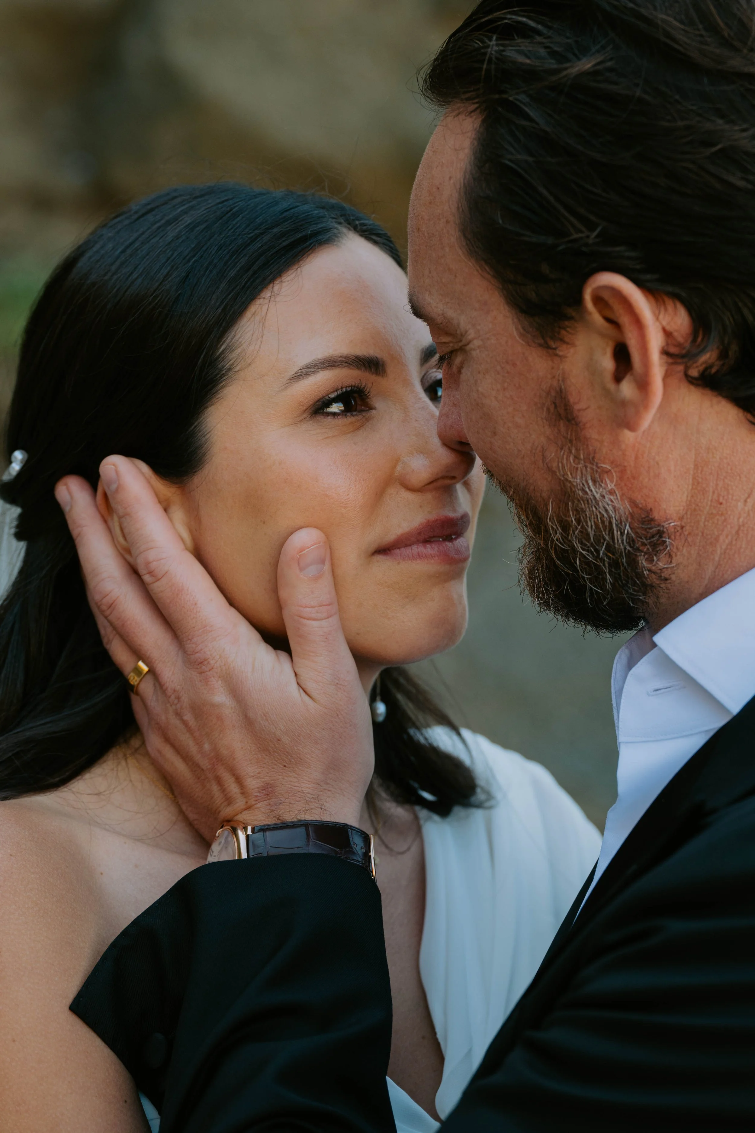 close up of Bride looking into grooms eyes as he holds her face