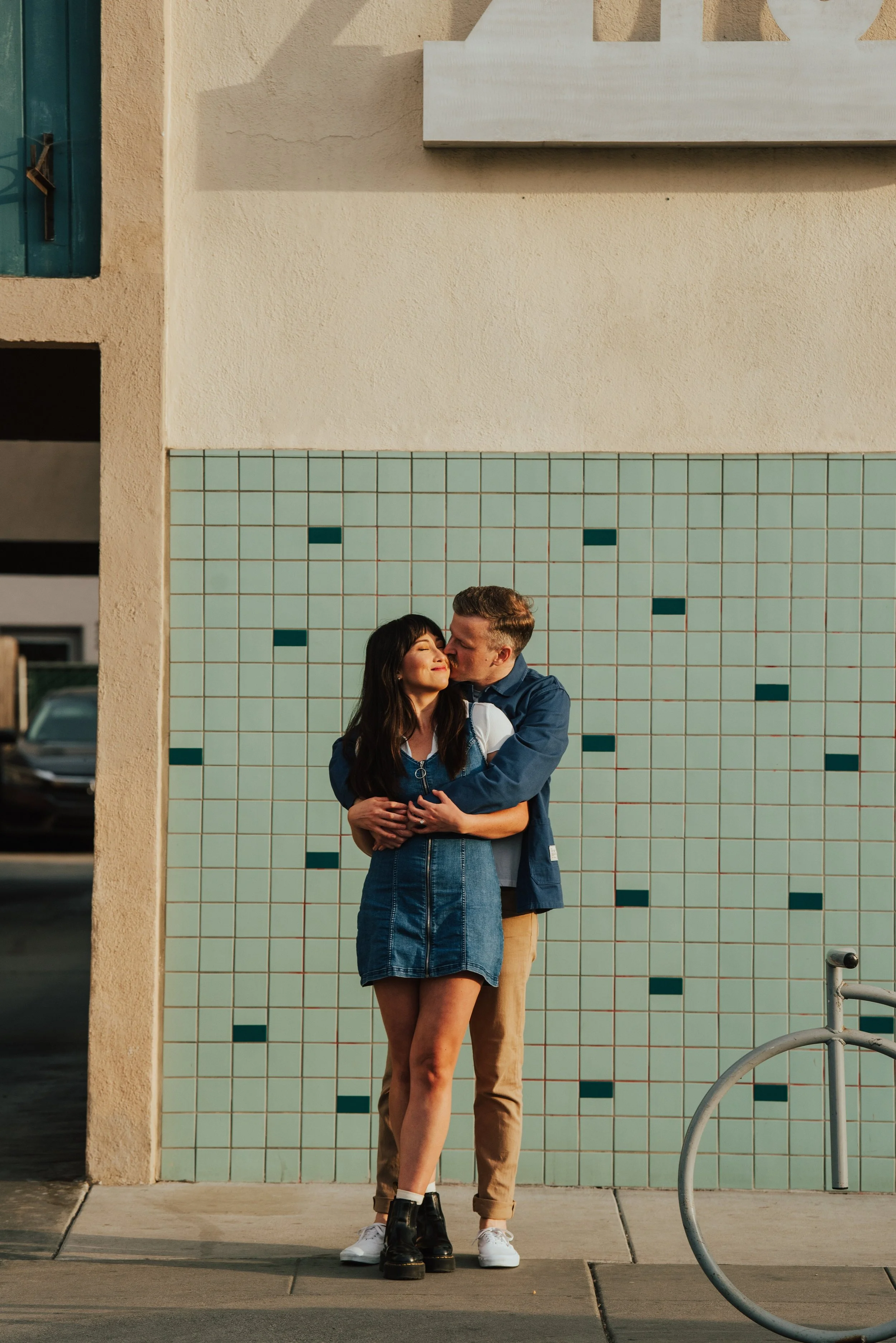 photo of guy hugging girl from behind and kissing her cheek