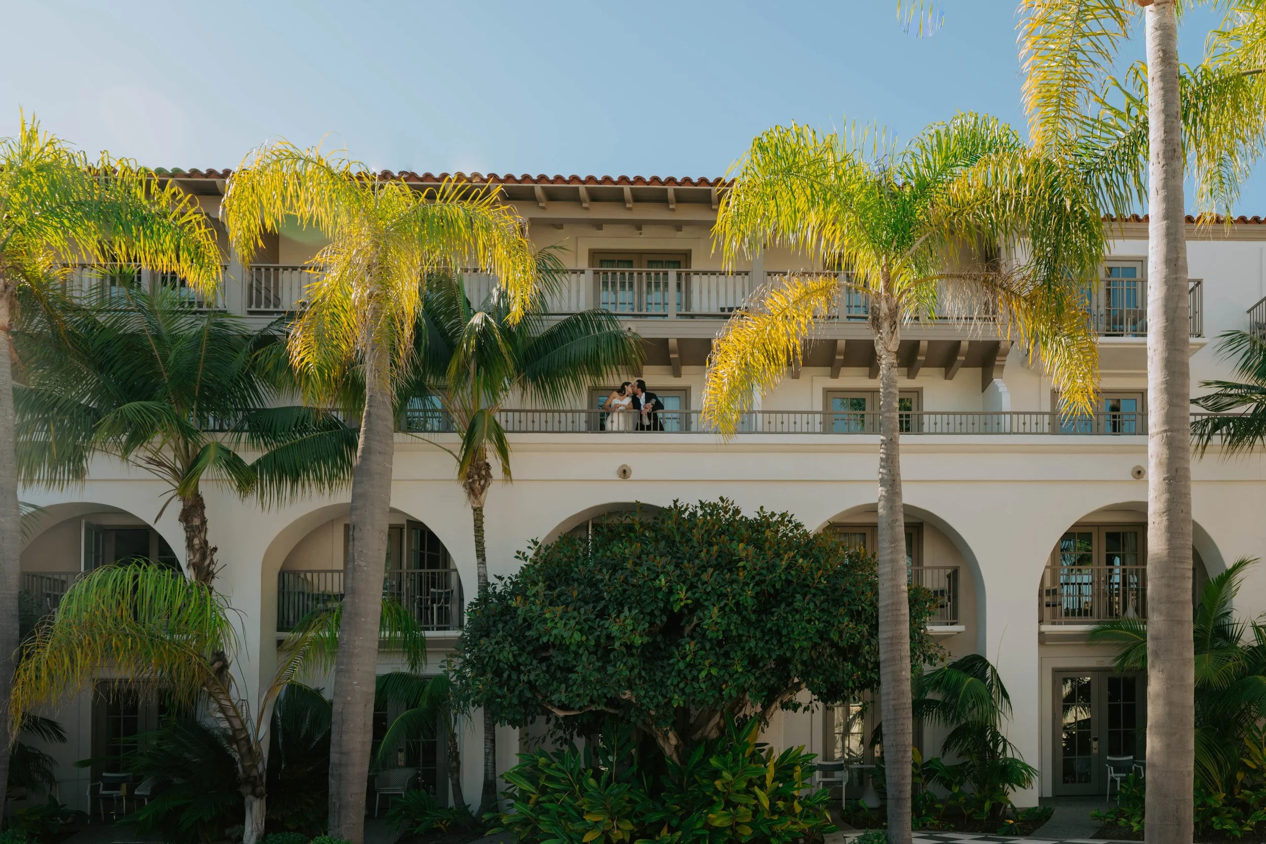 bride and groom kissing on a balcony. shot is a wide shot