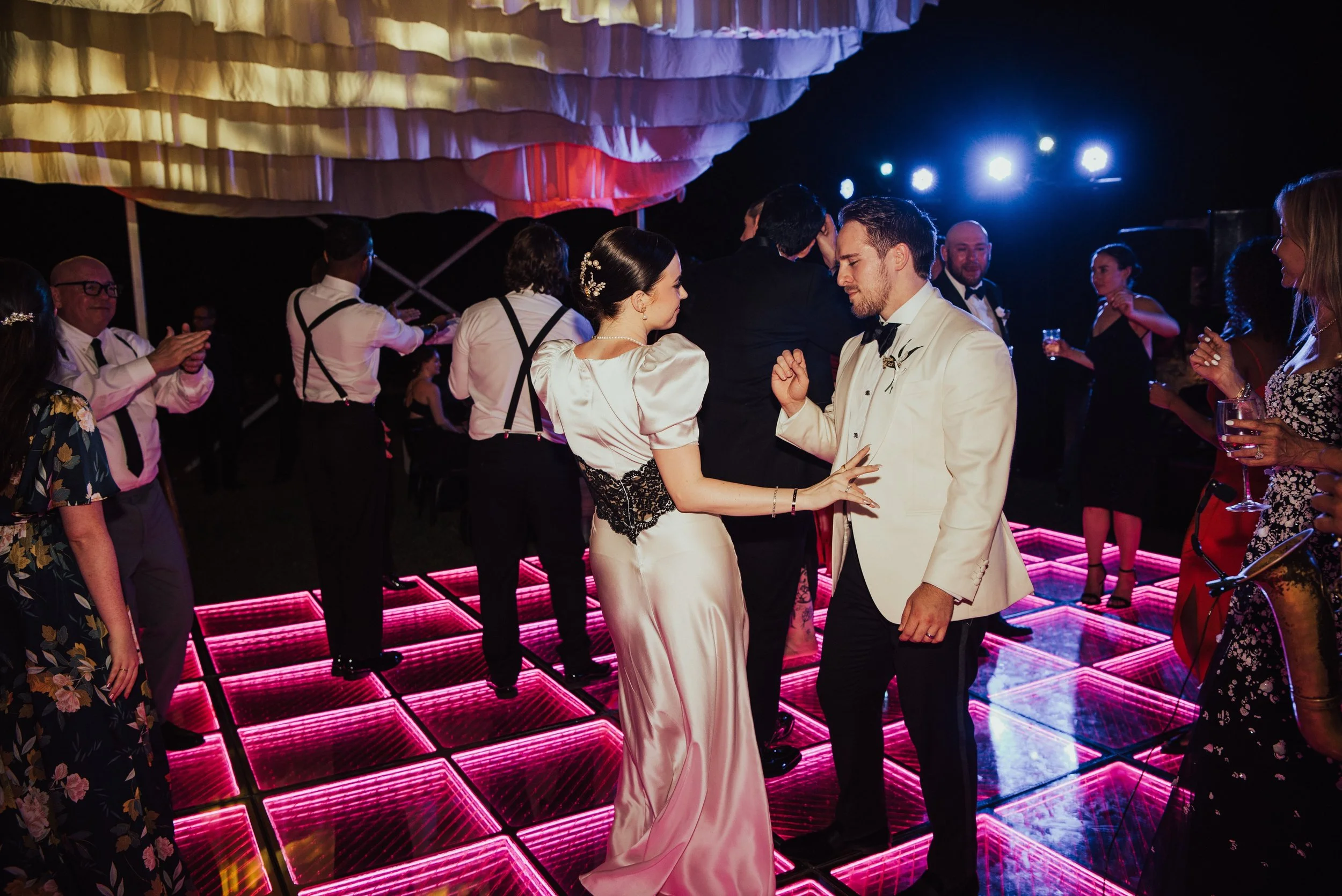bride and groom dancing on a pink dance floor