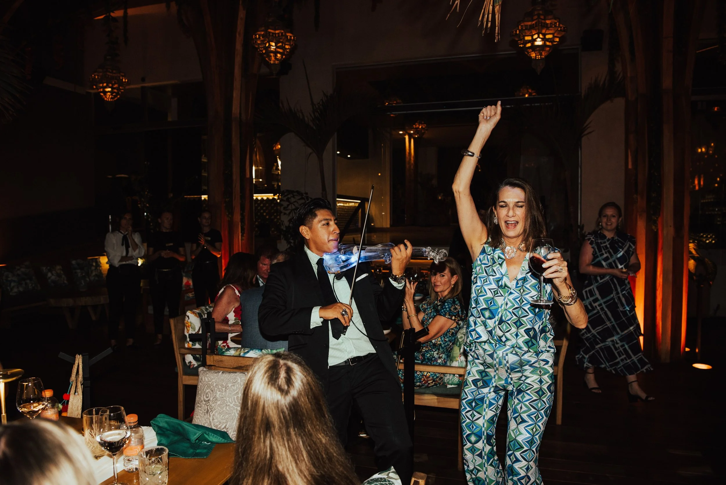 man playing electric violin and wedding guest dances next to him