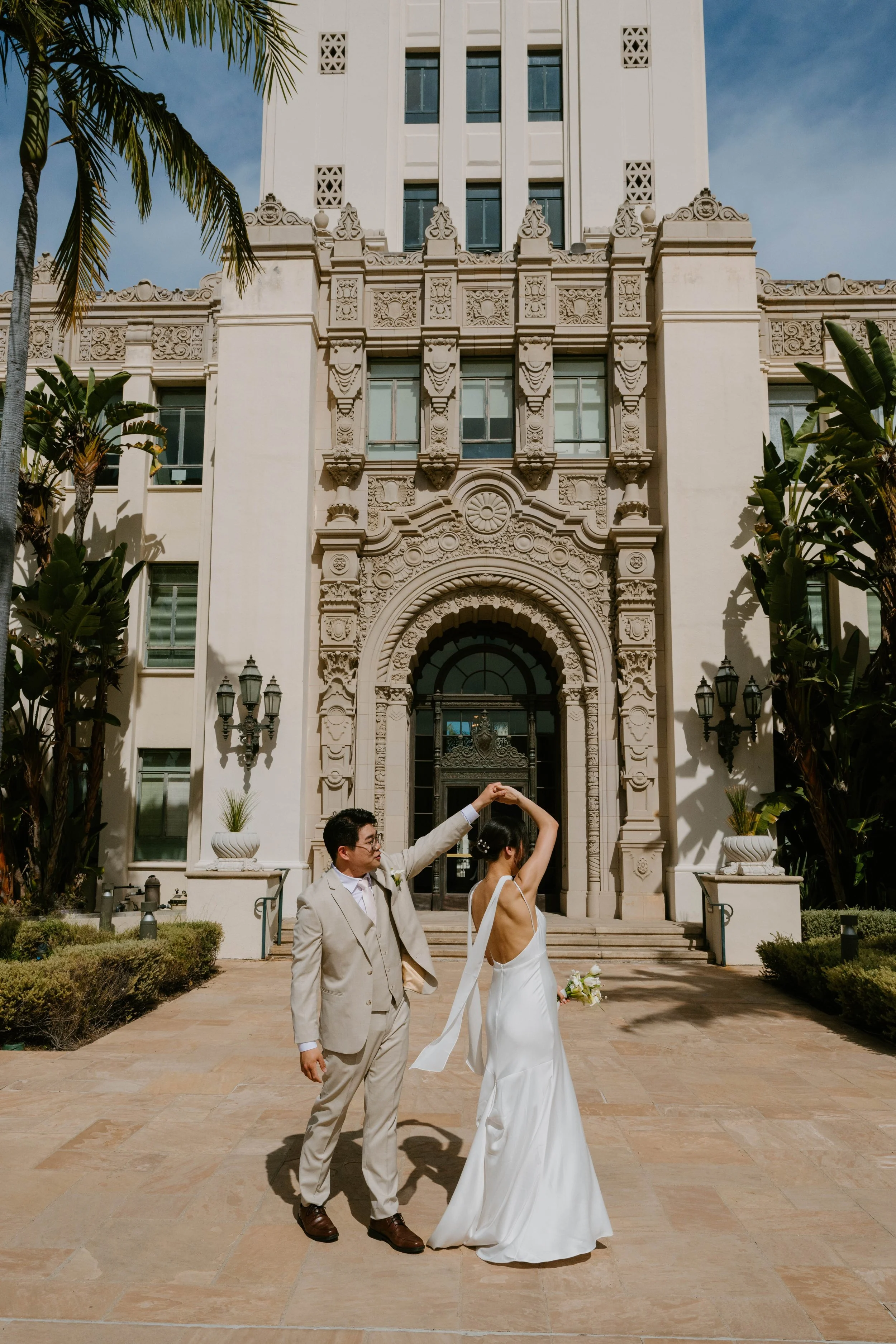 Groom Spinning Bride in front of the Beverly Hills City Hall. You can see the arched door way in the background