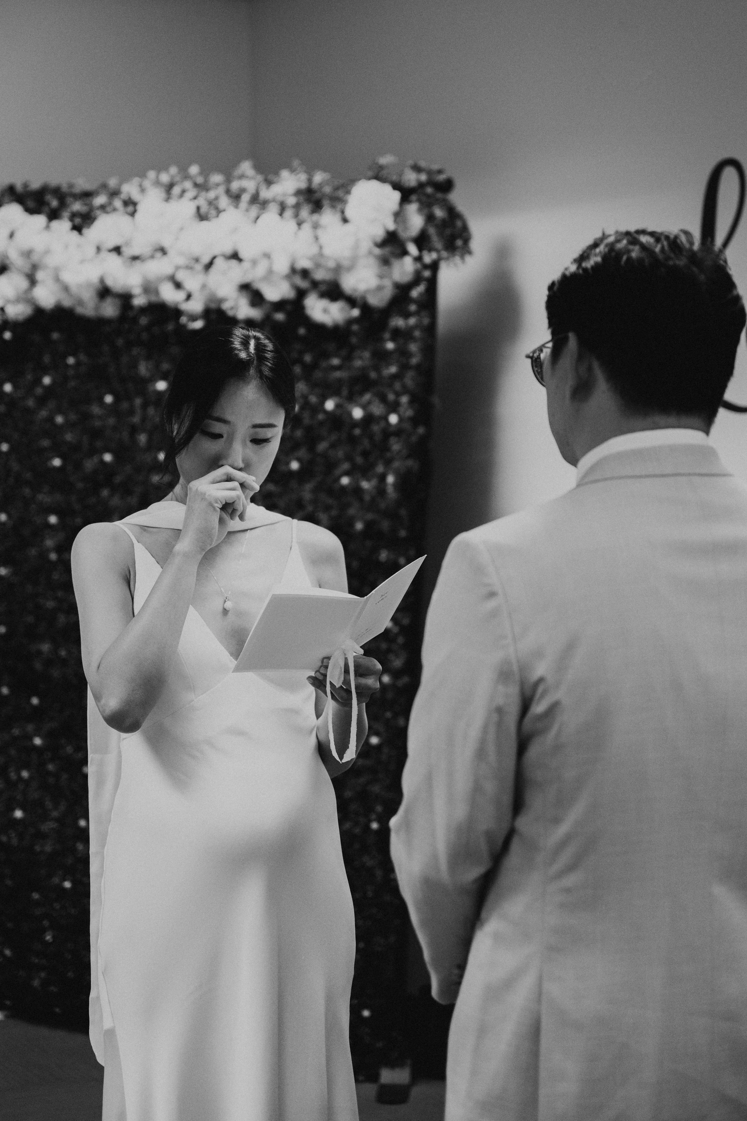 black and white photo of bride getting emotional as she reads her vows