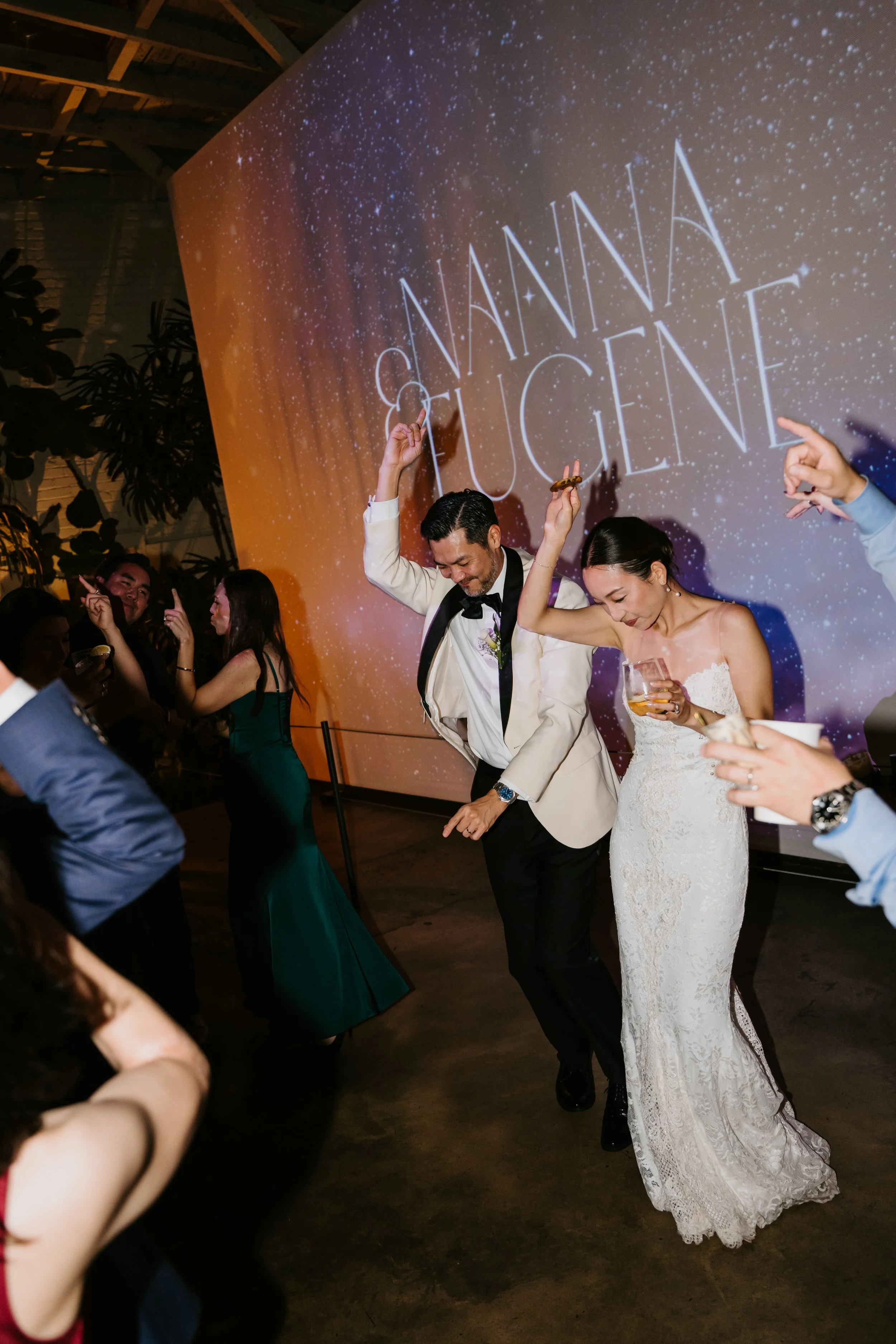 Bride and groom dancing as bride holds a drink in her hand