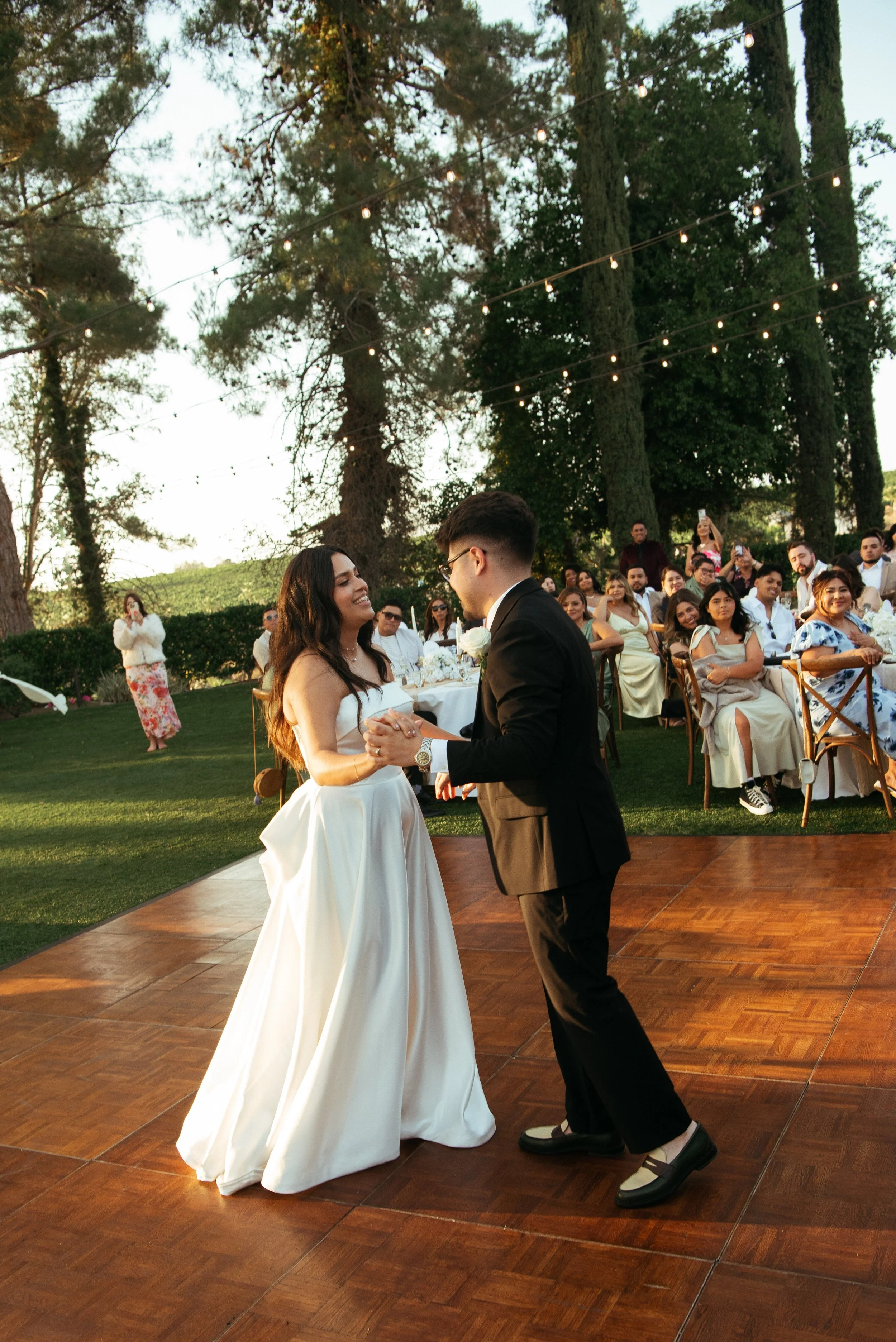 Bride and Groom dancing on a dance floor and guest seen in the background