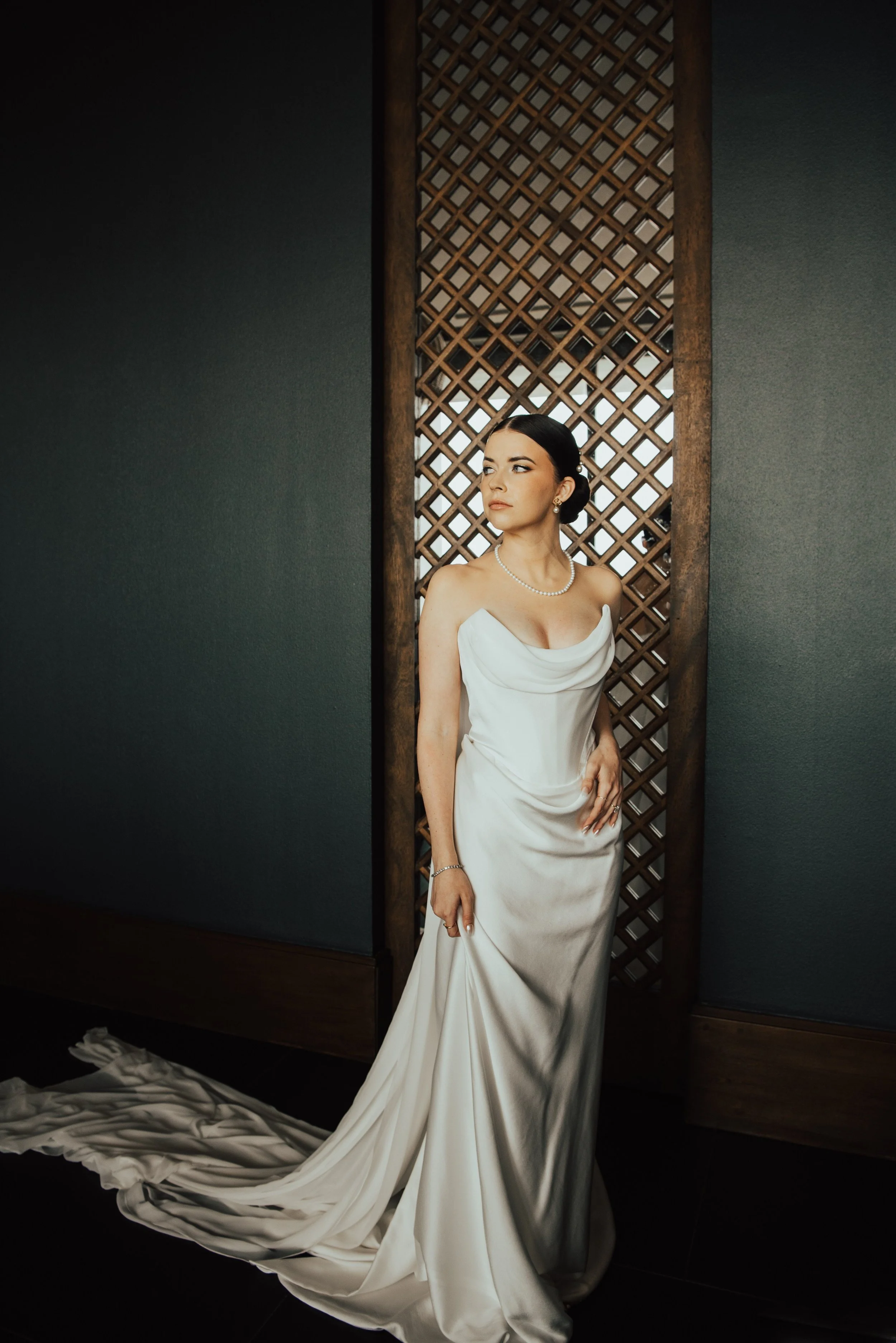 bride standing in wedding dress, looking off camera
