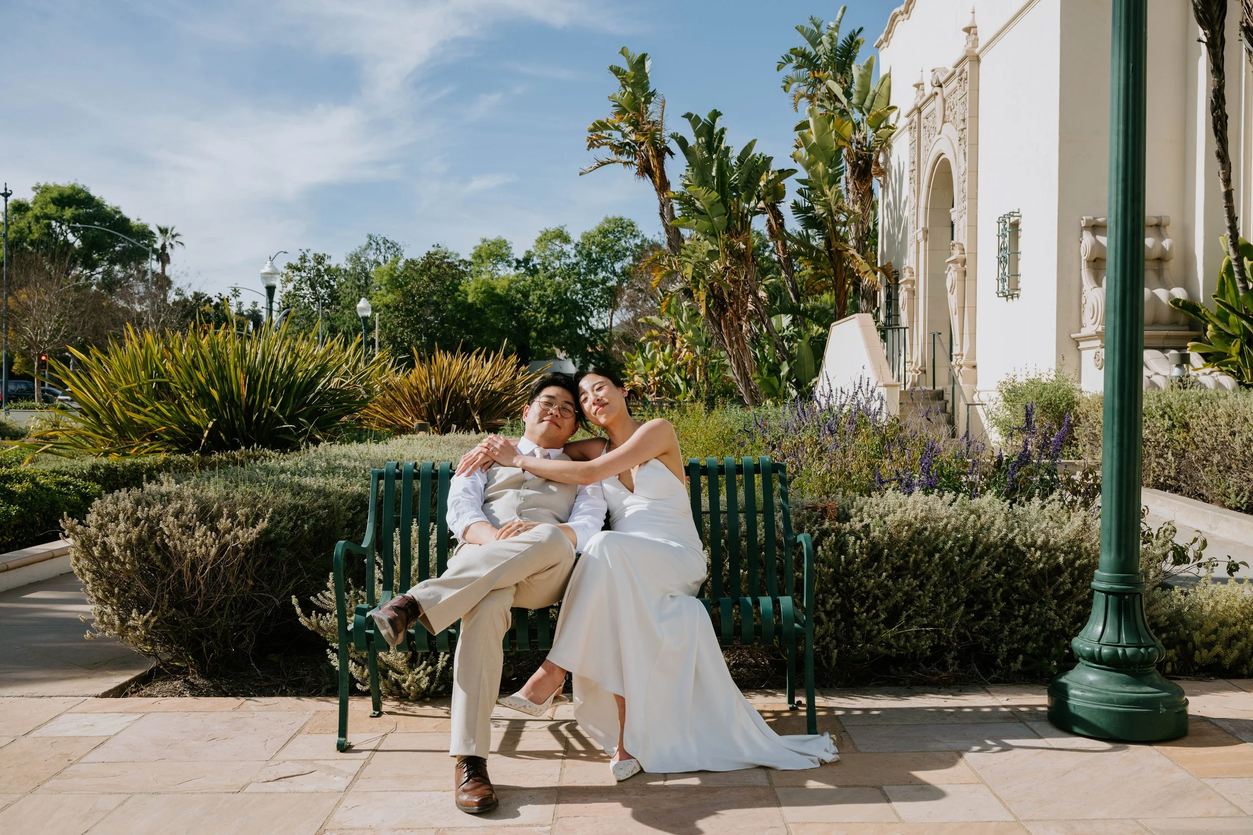 Bride and groom sitting on a bench relaxed after their wedding ceremony