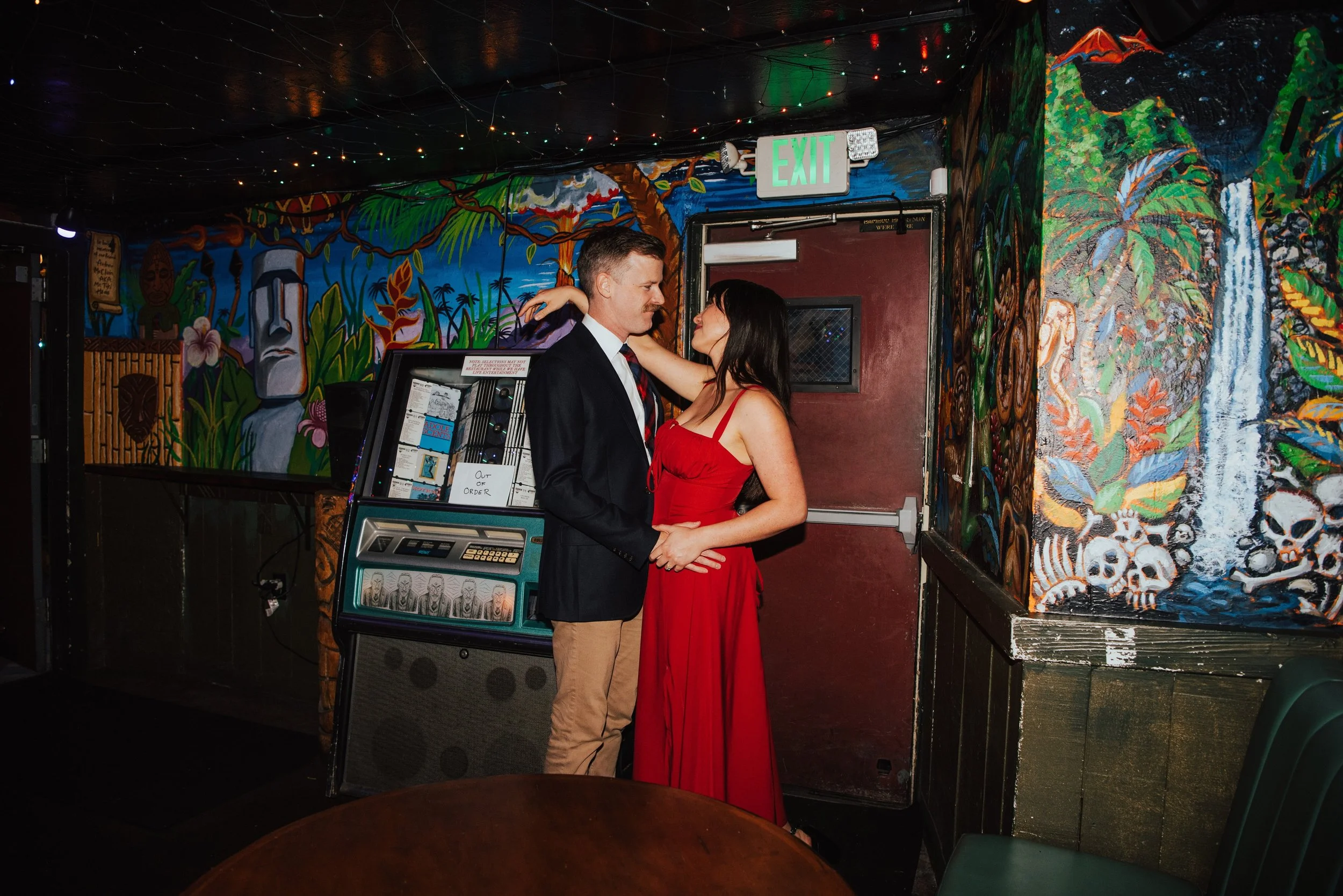 Couple embracing in bar in front of a CD jukebox
