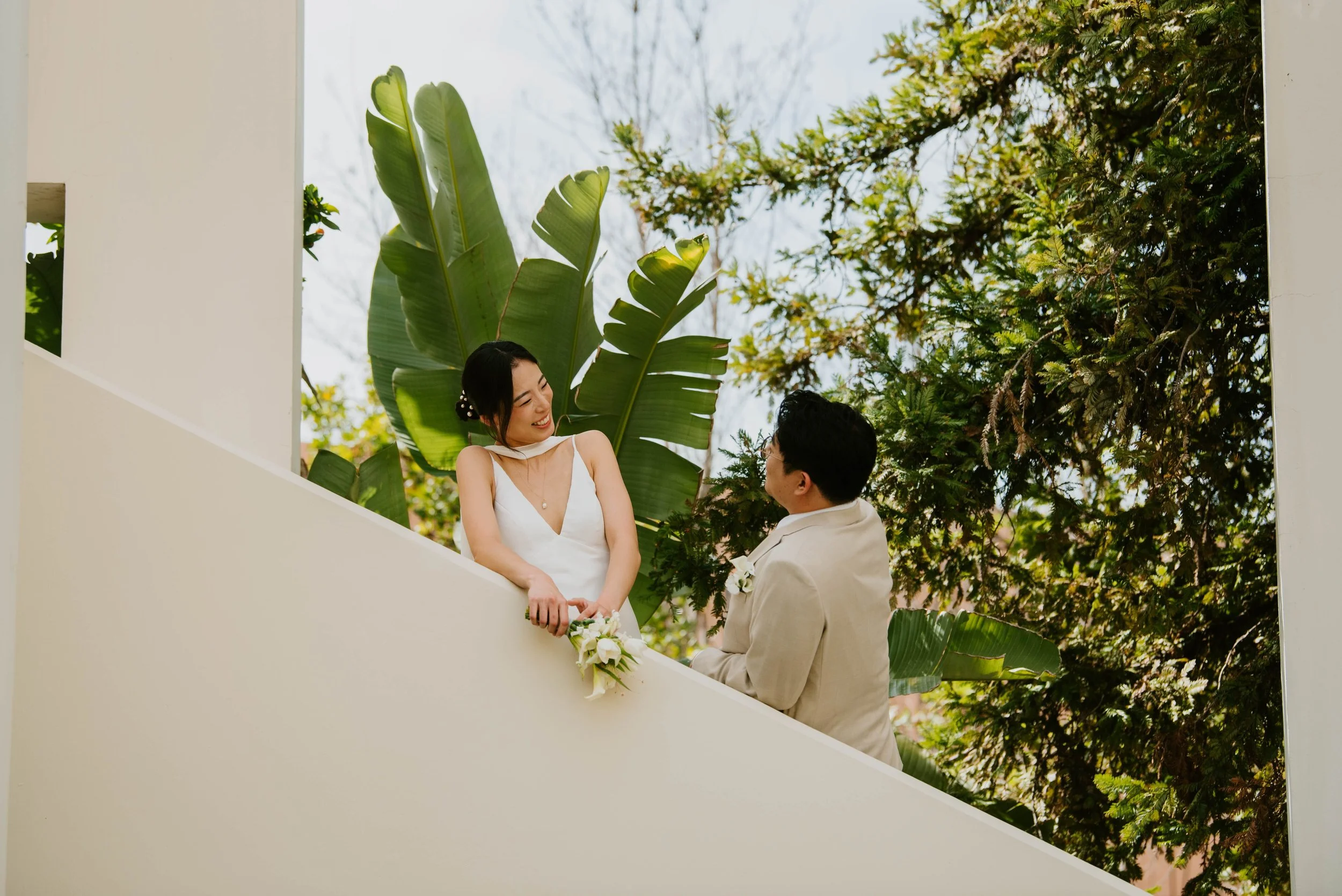 Bride smiling down at groom as he stands on a lower step