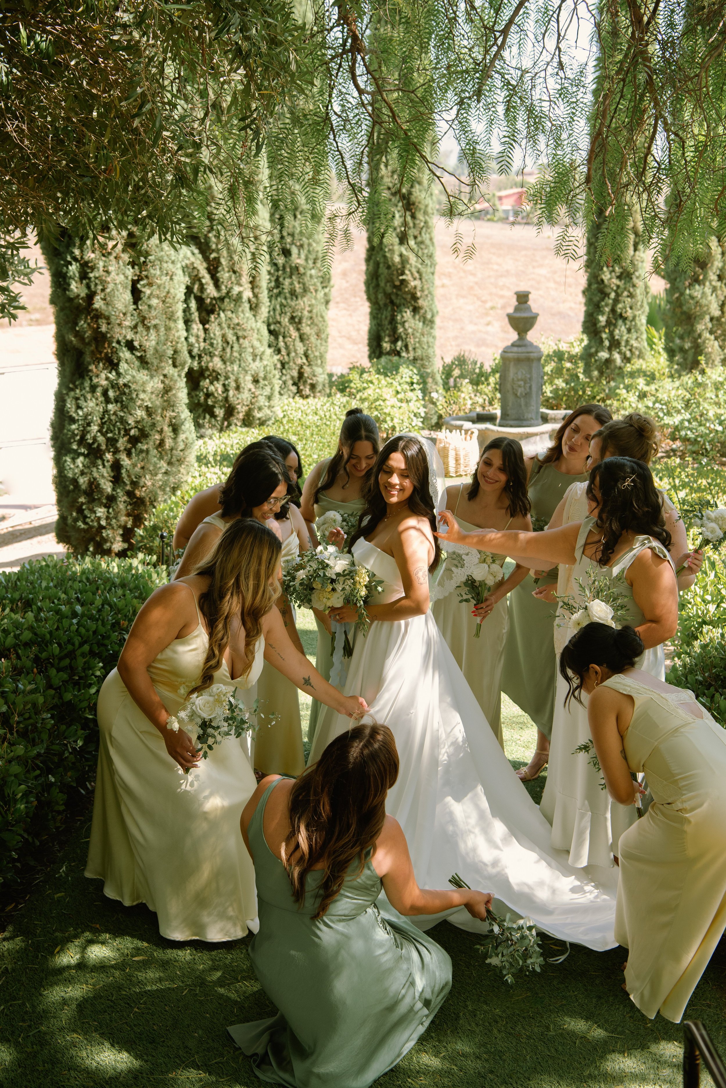 Shot of bridesmaids fluff the brides dress