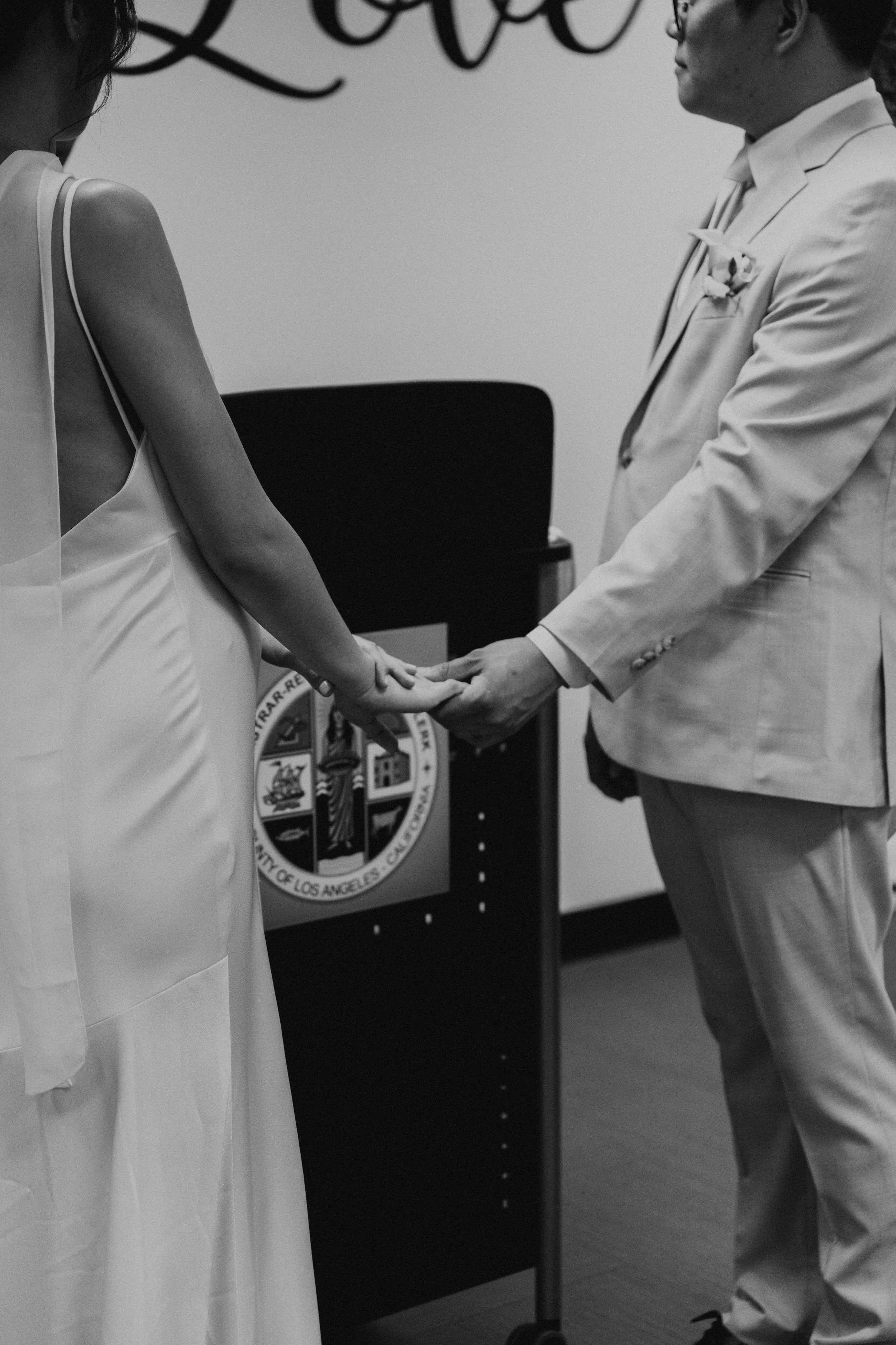 Black and white photos of bride and groom holding hands in civil wedding ceremony at Beverly Hills Courthouse