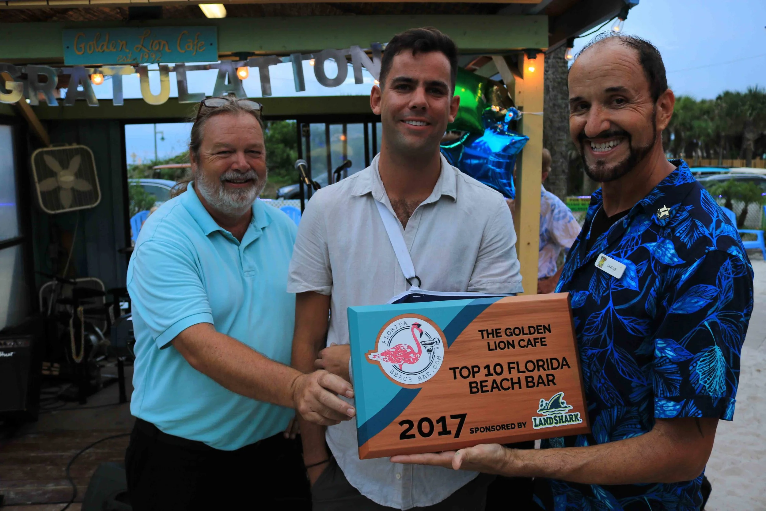 The leadership team at the Golden Lion Cafe accepts the 2017 Top 10 Florida Beach Bar award