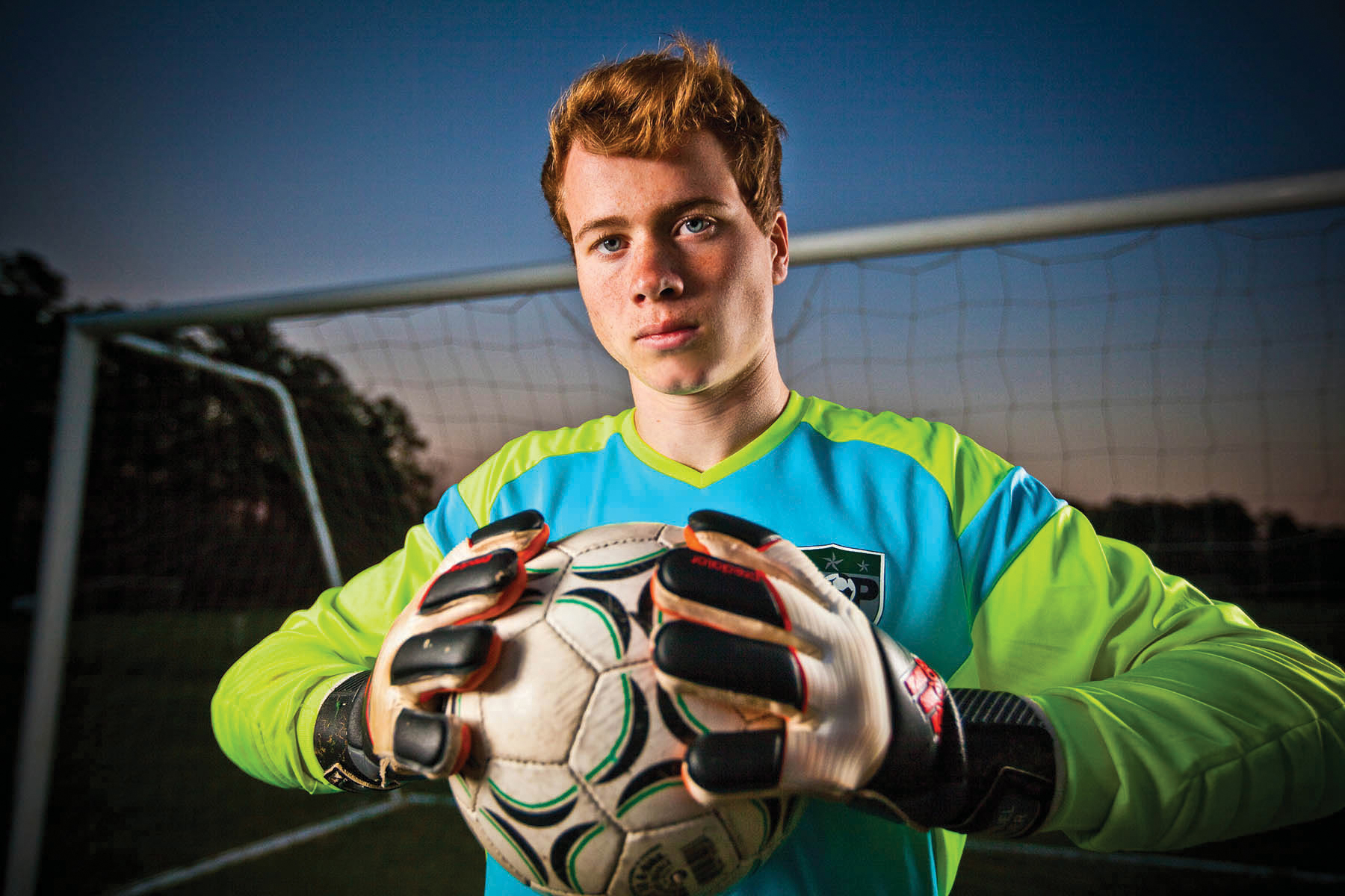 Photo of a high school senior boy posed with a soccer ball in front of a soccer net on the soccer field taken by wedding photographers in Baltimore ARWhite Photography (Copy)