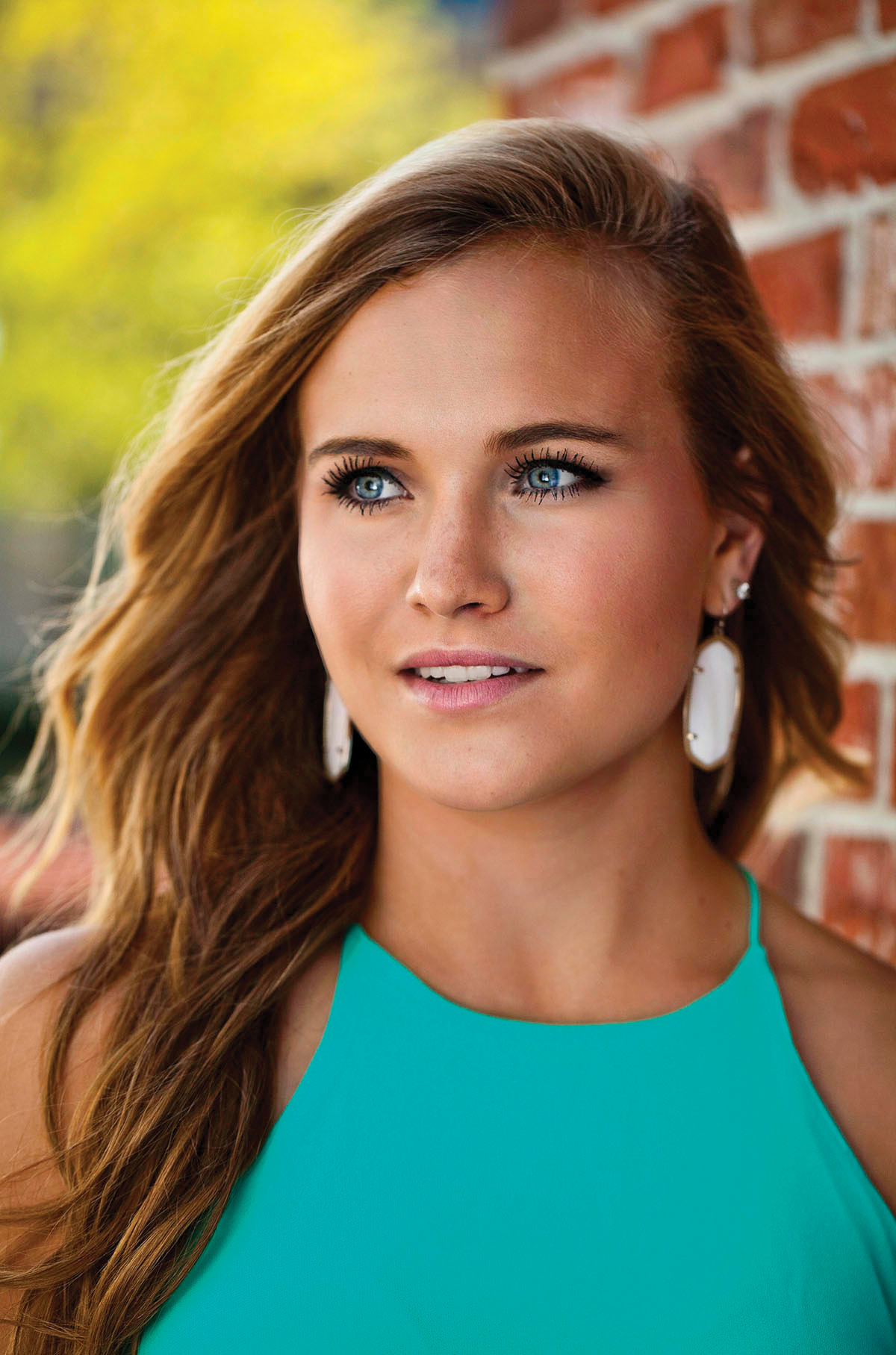 Photo of a high school senior girl wearing a teal top next to a brick wall taken by wedding photographers in Baltimore ARWhite Photography (Copy)