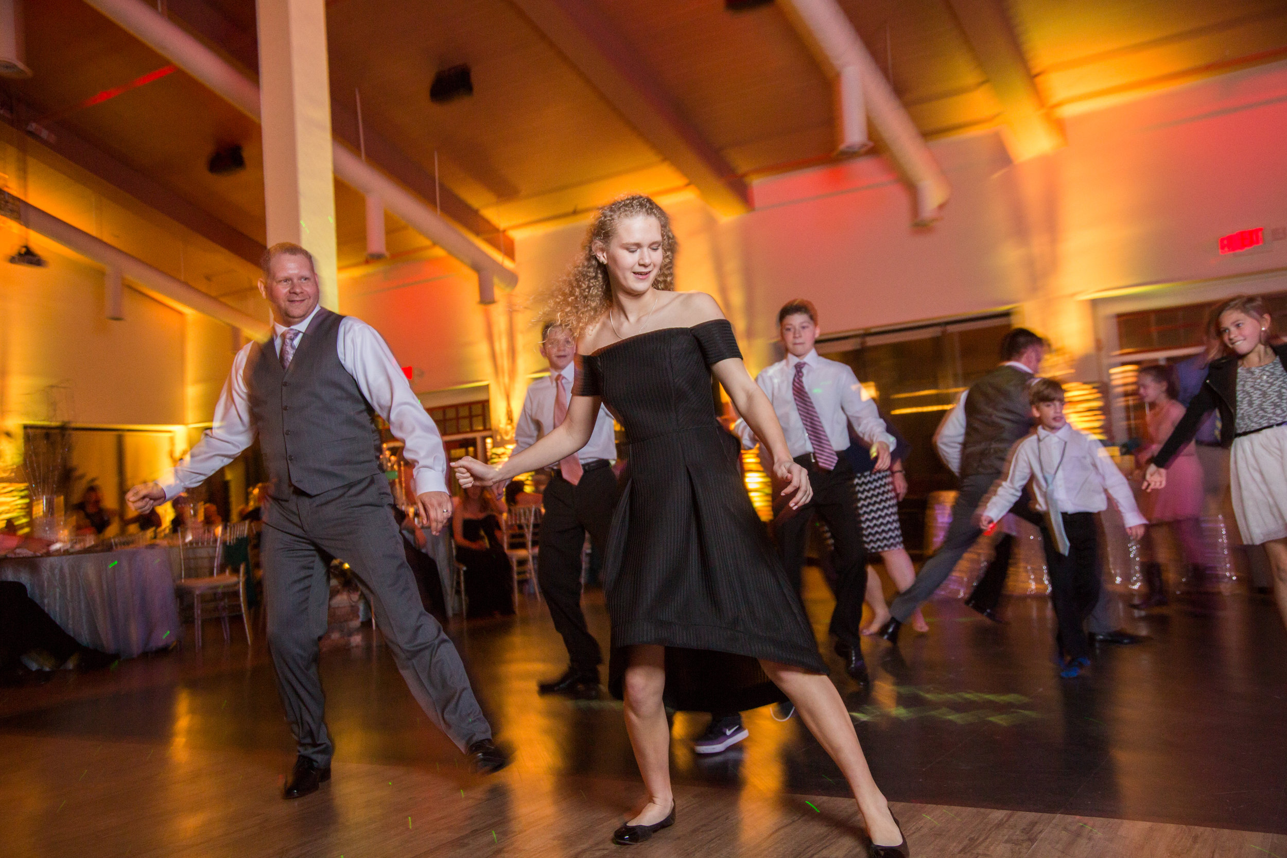 The groom Kennith and his daughter dance together on the dance floor during the wedding reception.