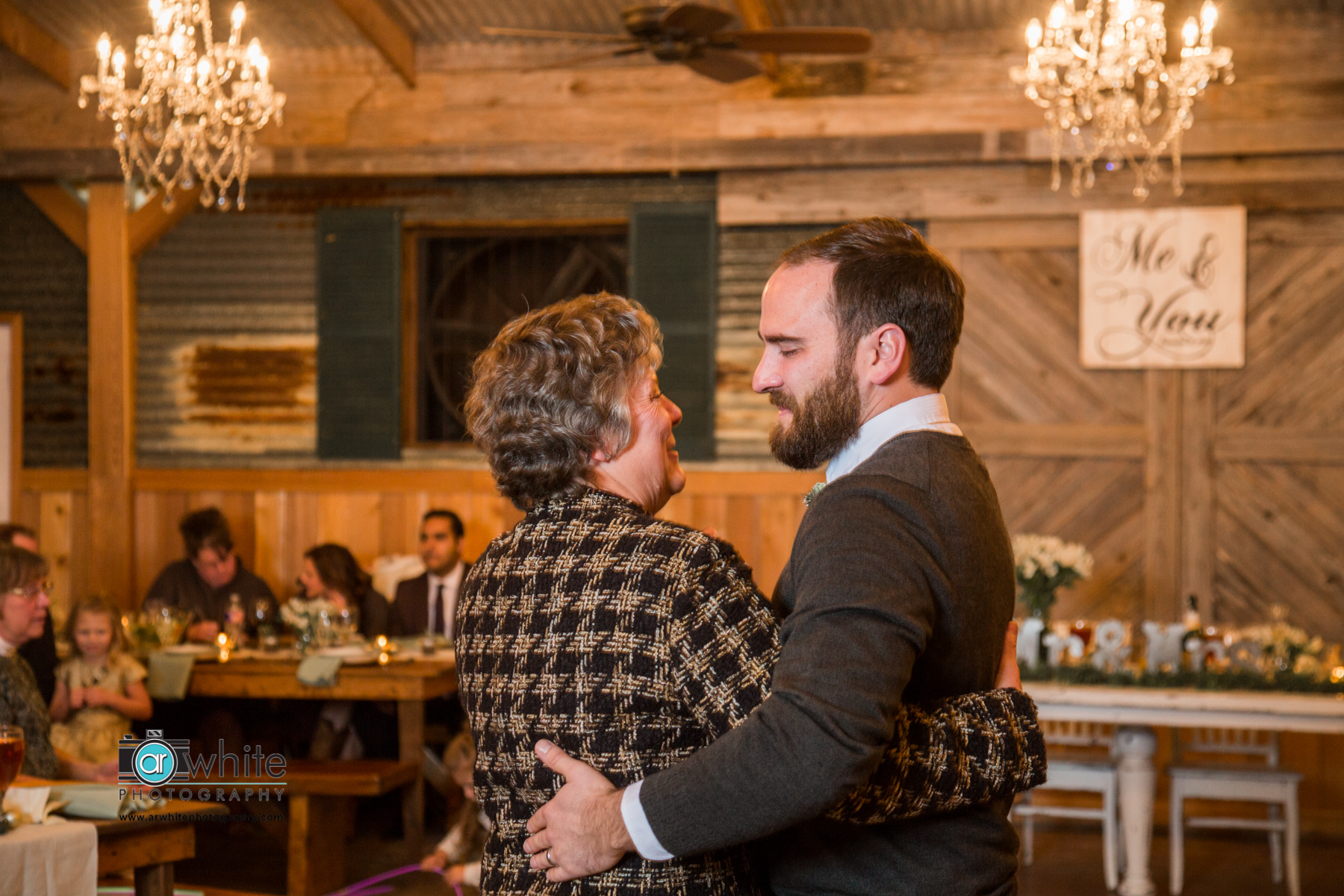 Mother and son dance at a barn wedding venue.