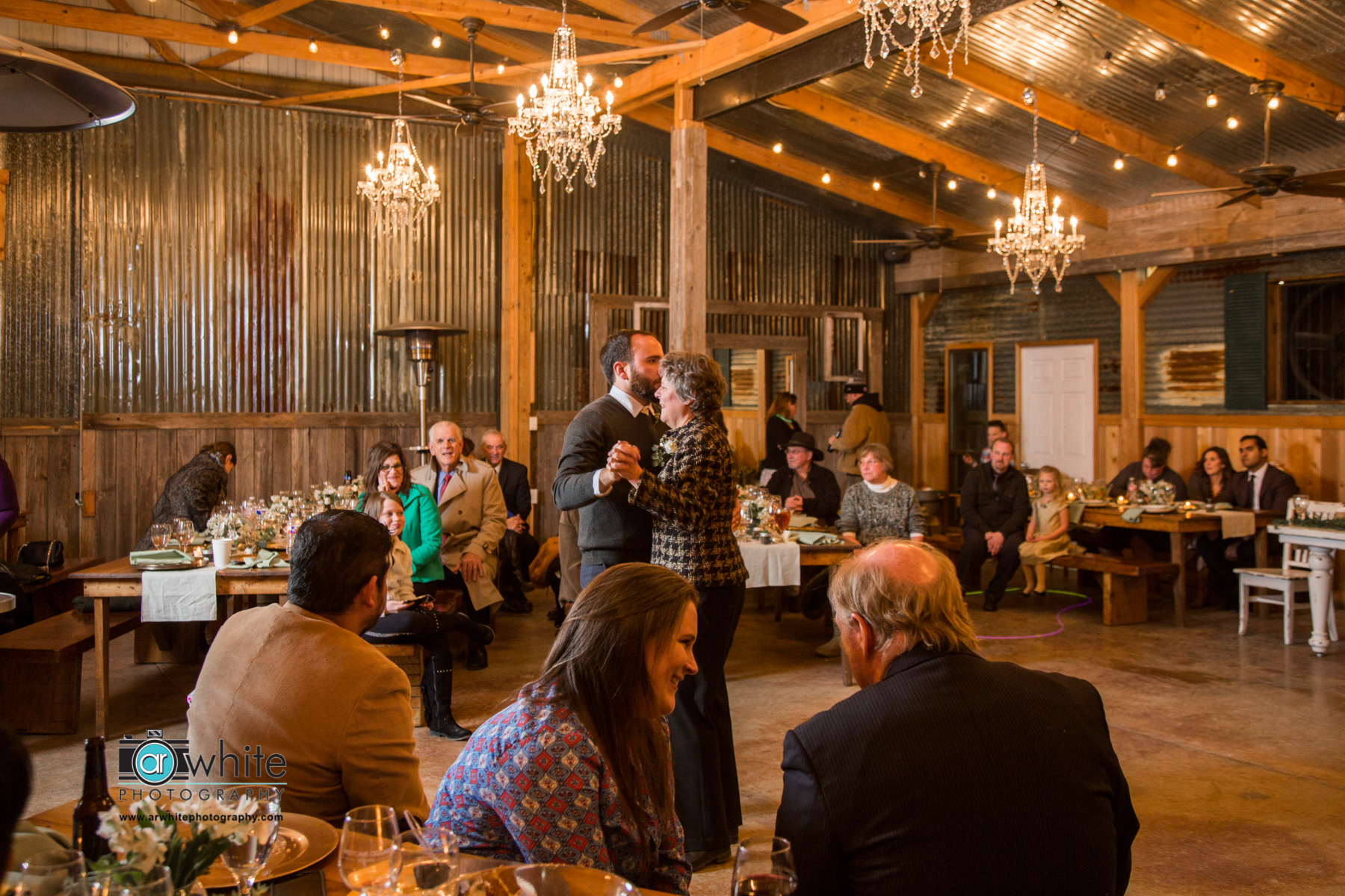 Mother and son dance at a barn wedding venue.