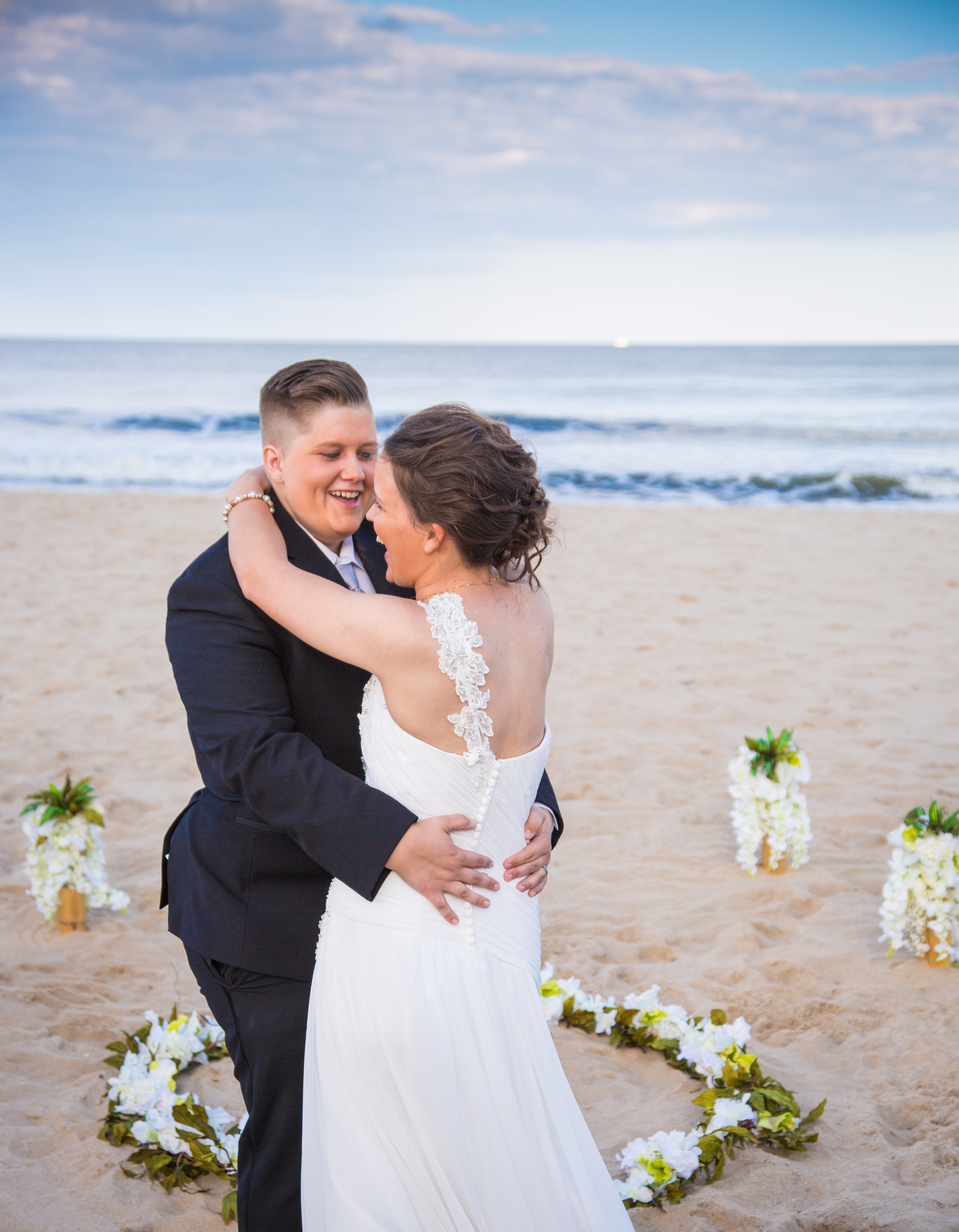 The newly married couple shares their first dance on the sand at the beach.