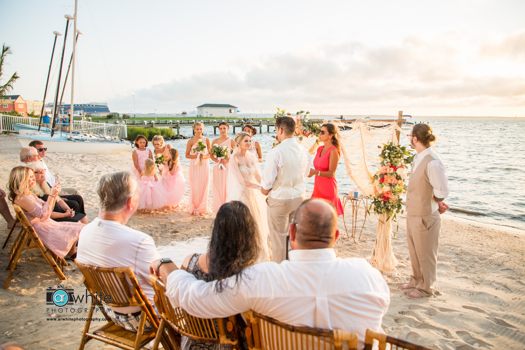 A couple recite their wedding vows on the beach at sunset.