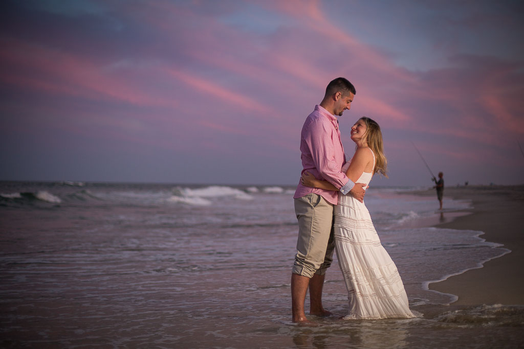 Photo during an Assateague engagement session of a woman in white flowy dress and her fiance at Assateague during sunset taken by wedding photographers in Baltimore ARWhite Photography (Copy)