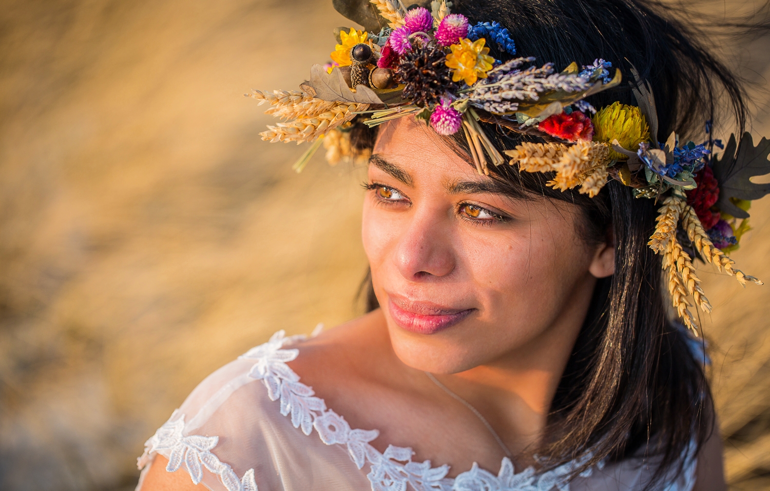 A beautiful bride with a flower crown looks off into the sunset on her wedding day.