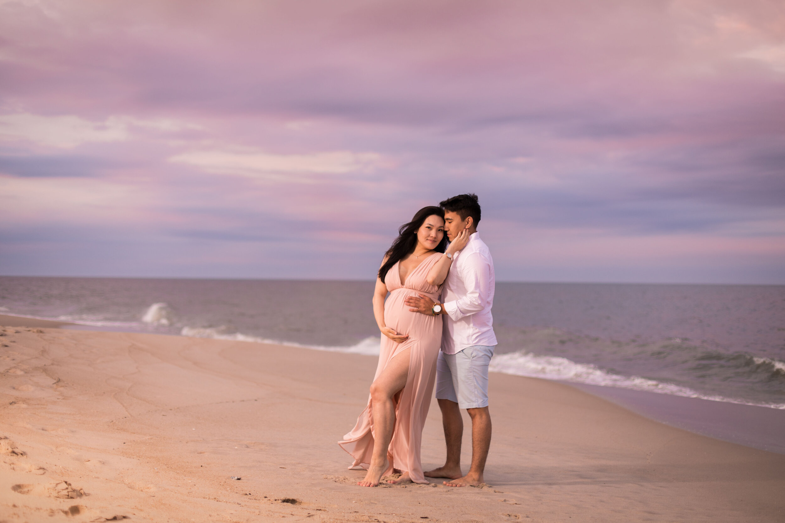 Photo of a pregnant woman in long flowy pink dress on the beaches of Assateague during her OCMD maternity session taken by photographers in Ocean City Maryland ARWhite Photography. (Copy)