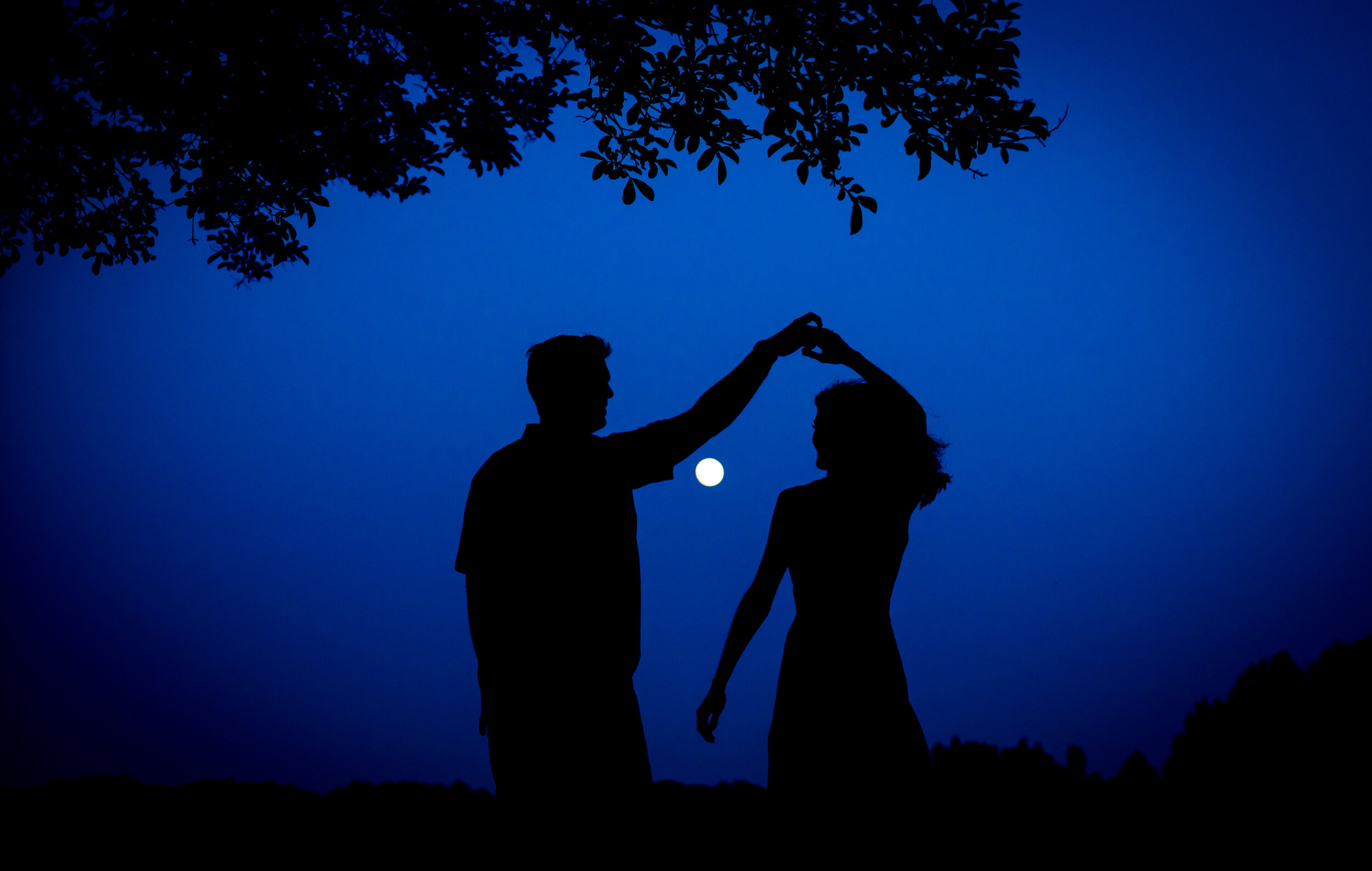 Photo of an engaged couple in silhouette dancing on a full moon night  during their engagement session taken by wedding photographers in Baltimore ARWhite Photography (Copy)