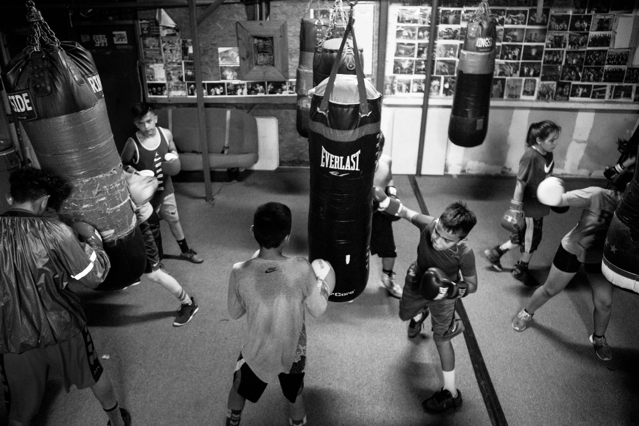  Victor De Los Santos Jr., 12, center, punches a bag at the Ramos Boxing gym with other members of the Junior Olympics team.&nbsp;Many of the young athletes devote hours in the gym to continue a family tradition they say "runs in their blood." 
