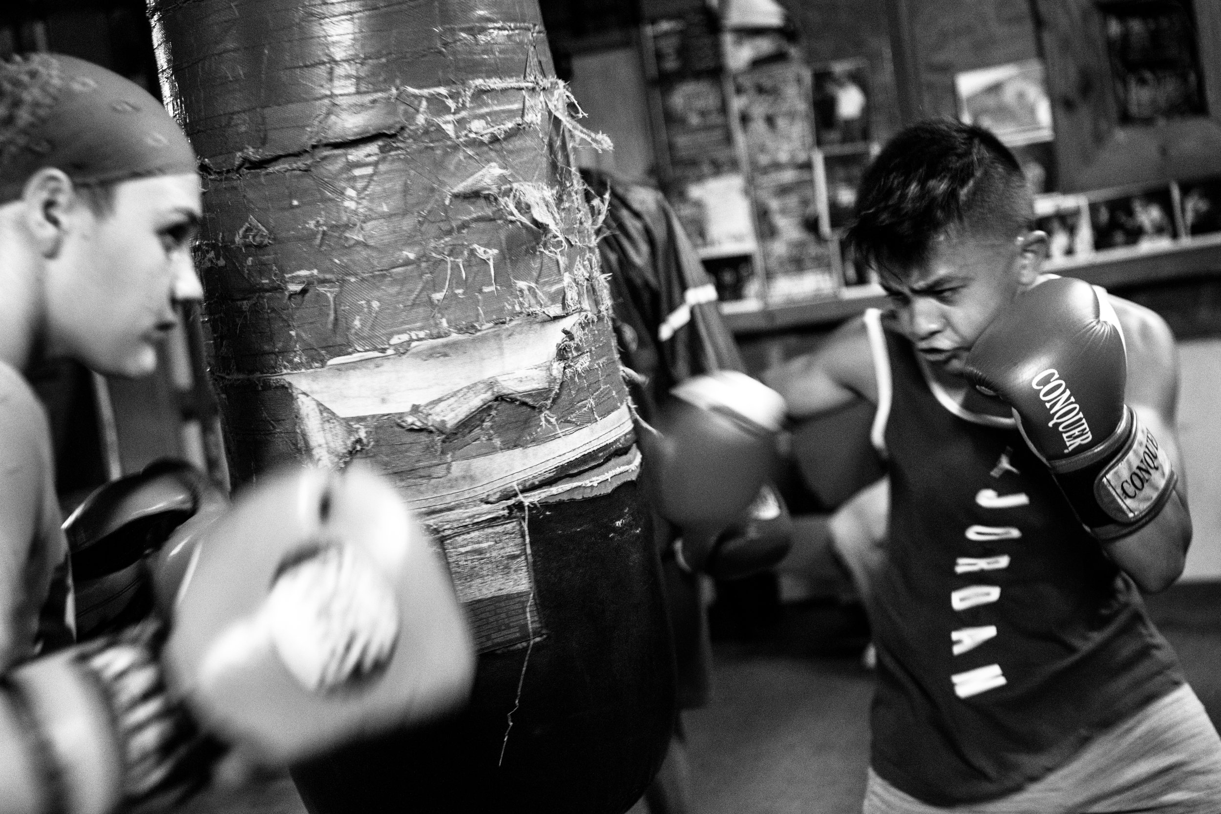  Reina Tellez, 14, and AJ Ramos, 13, take turns punching during a bag drill at the Ramos Boxing gym in the South Side neighborhood of San Antonio, Texas.&nbsp; 