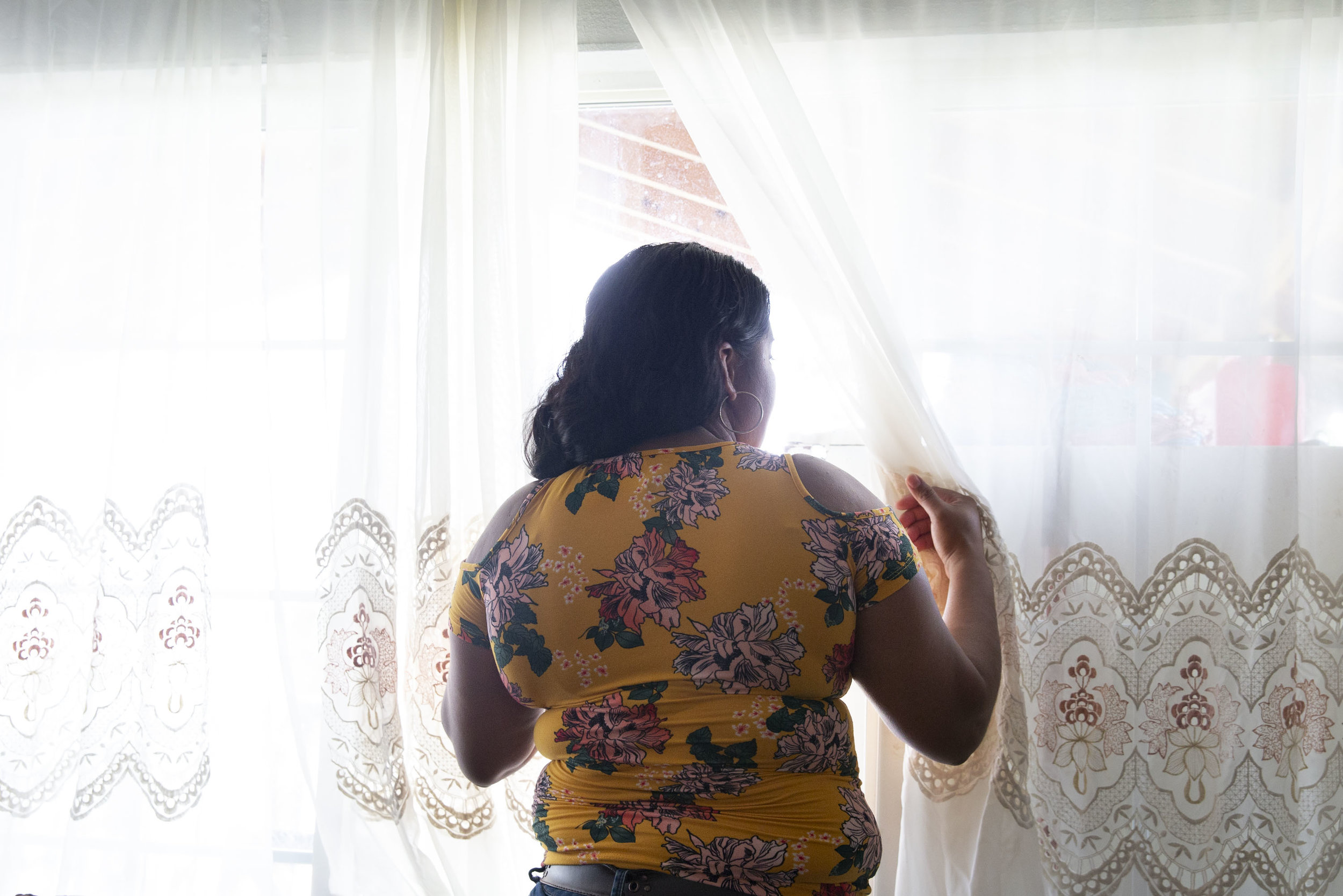  Lizeth Rosales, an asylum recipient from Honduras, looks out the window at her mother's mobile home in Kyle, Texas, on June 22, 2018. Rosales recieved asylum in 2017 after experiencing domestic violence from her son's father. “I get another chance a