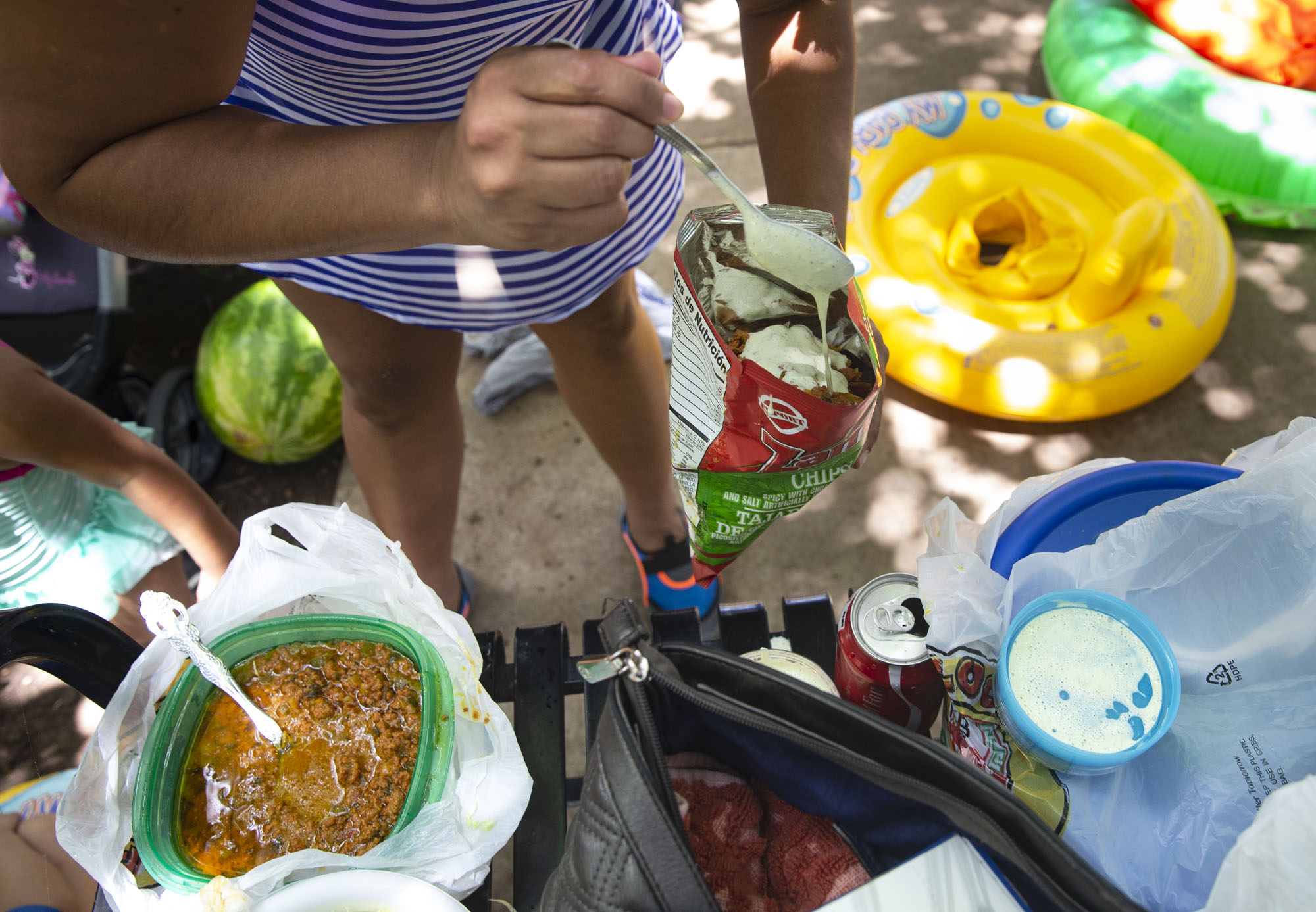  Rosales prepares an  antojito,  a type of snack she said is popular in Honduras. Rosales and her family enjoy going to Sewell Park and bring along a day’s worth of food to eat while they enjoy the river.  