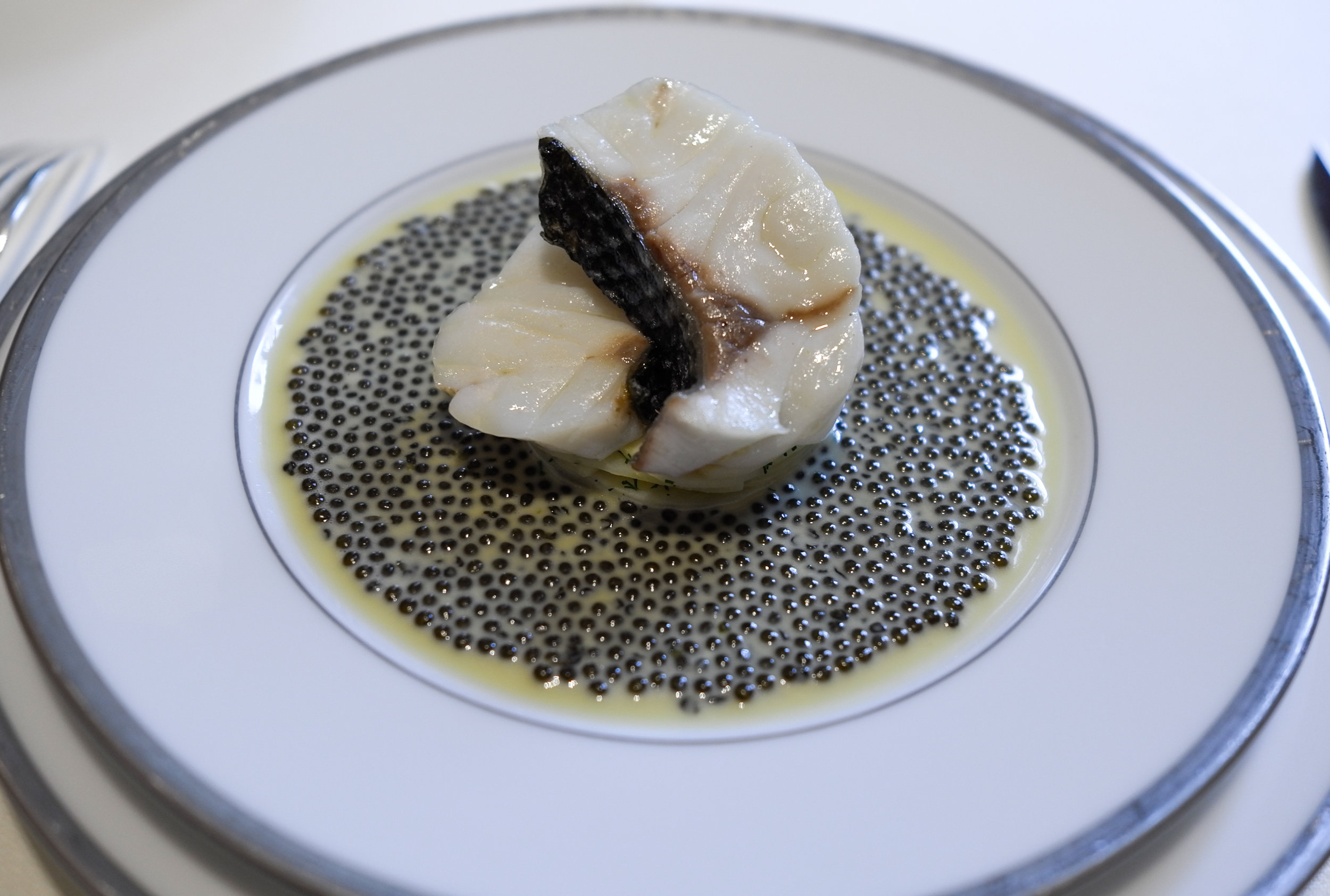 Escalopines de bar à l’émincé d’artichaut, nage au caviar golden