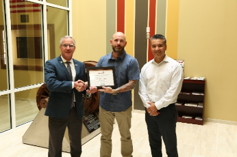 Philip Austin receives his AWG Employee of the Quarter Certificate. Pictured left to right: Yorktown CEO Bryan Dyer, Philip Austin, and Program Manager Jesse Cisneros