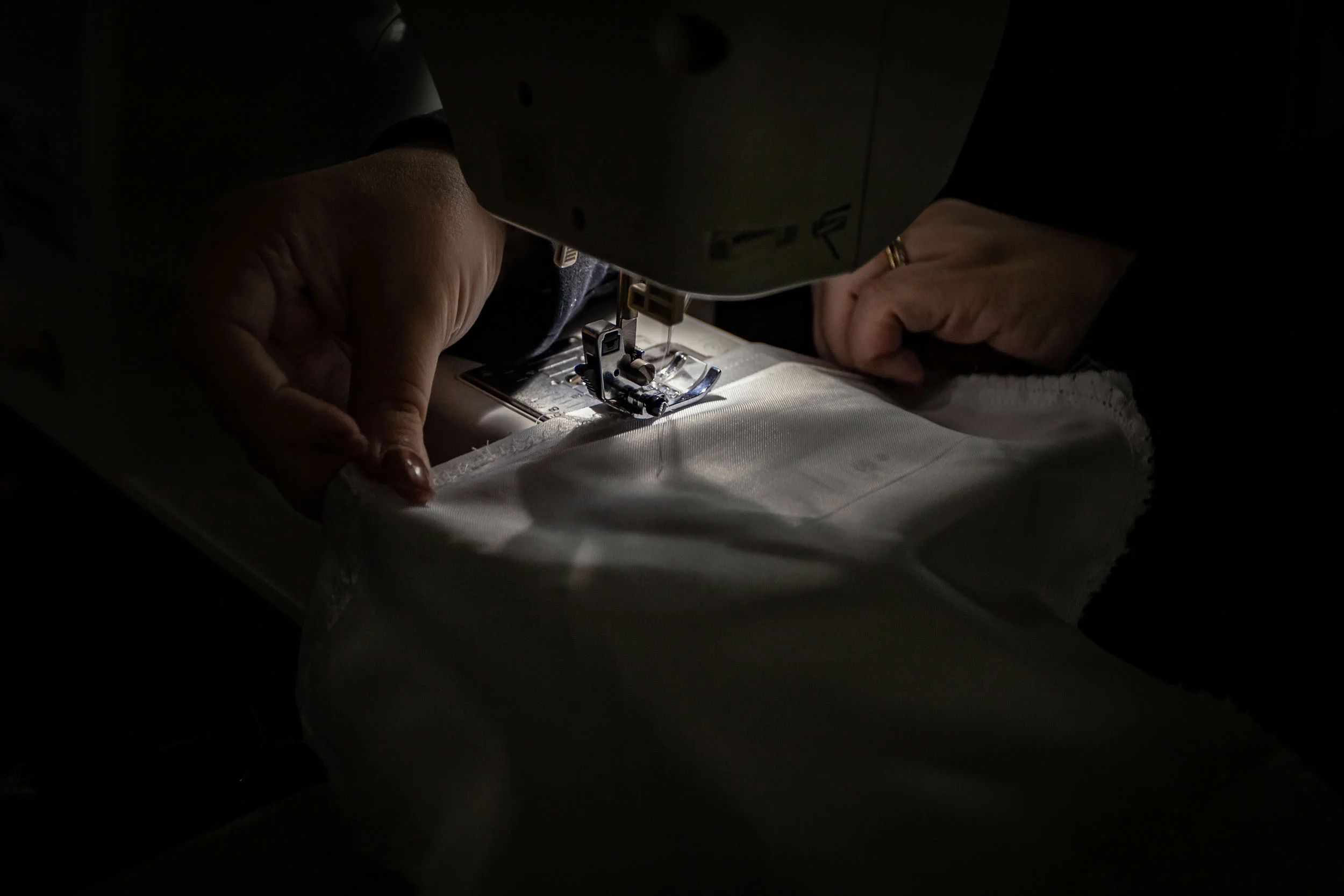 Lottie sewing a hood for an evening ceremony.